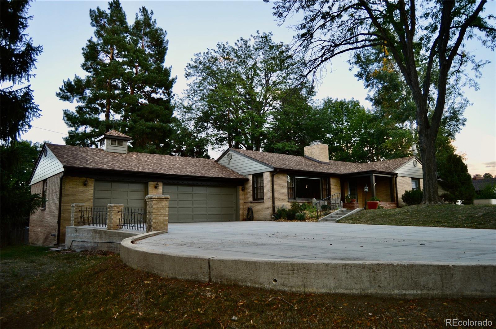 Some homes simply belong to their setting. With its winding streets, generous lots and mature trees, Wheat Ridge’s Bel Aire neighborhood offers a fitting backdrop for this 1957 mid-century ranch.Set on .52 acres, 4050 Field Drive offers more than 2,200 square feet, all on one level. Floor-to-ceiling windows frame the outdoors in the expansive living room, where a stately fireplace creates a striking first impression. The vaulted family room has a character all its own, with exposed beams, skylights and a Colorado flagstone fireplace. A separate heated sunroom overlooks the backyard in every season. With two generous living spaces, there’s room to host a crowd, settle in by the fire or find a quiet corner.The kitchen preserves a piece of the home’s history with original 1957 metal cabinetry, freshly painted and paired with new countertops and backsplash. A newly built butler’s pantry adds extensive cabinetry, counter space and storage- along with fresh interior and exterior paint to complement the home’s original character. Three spacious bedrooms and two vintage baths complete the one-level layout.Outside, a sprawling covered deck opens to a tree-shaded yard with space to gather, garden, play or imagine what comes next. Mature trees lend the property a sense of privacy and permanence, and the lot offers a connection to the outdoors from nearly every gathering space. An attached three-car garage adds exceptional utility for a home of this era.The architecture, the land and the neighborhood all tell the same story: 4050 Field Drive is a place to make your own while appreciating everything that makes it one of a kind.