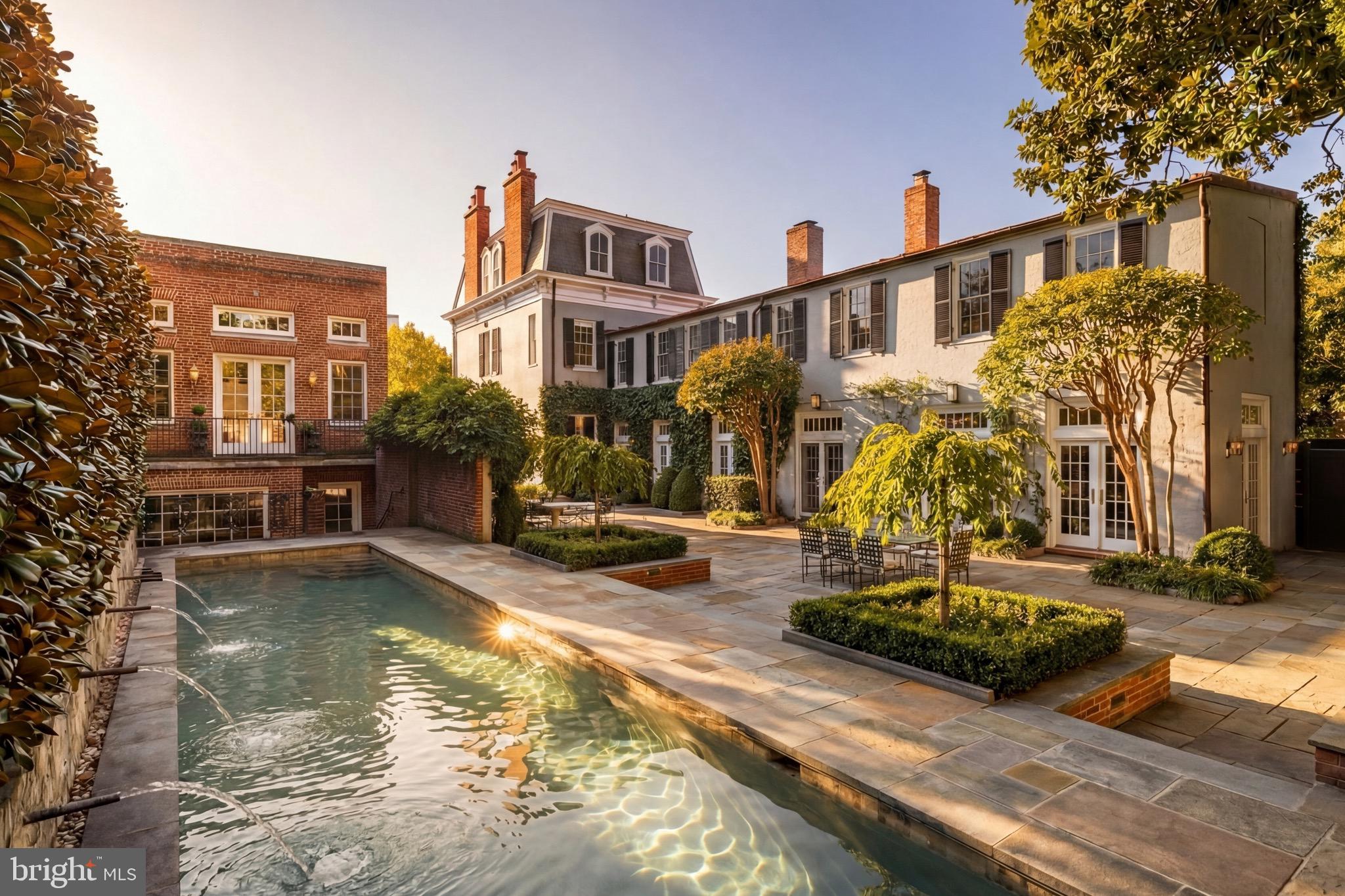 Set along one of Georgetown’s most established residential blocks, 3117–3121 O Street NW presents a rare townhome compound offering exceptional scale, privacy, and versatility. Originally built in 1900 and comprehensively remodeled in 2019, the property encompasses approximately 7,200 square feet across a primary residence and a fully integrated guest house.The main residence honors classic Georgetown architecture while delivering a highly livable, thoughtfully modernized layout. Formal living and dining rooms anchor the main level, each defined by fireplaces and gracious proportions. The kitchen opens directly to the central courtyard through French doors, creating a seamless flow between interior and exterior spaces. Designed for both everyday living and entertaining, the kitchen is outfitted with Wolf and Sub-Zero appliances, multiple refrigeration zones, dual wine storage, and a breakfast area with its own fireplace.Outdoor living is a defining feature of the property. The private, landscaped courtyard is centered around a lap pool with an automatic cover and is complemented by fountains, flagstone patios, and an outdoor kitchen, forming a tranquil retreat rarely found in the heart of the city.The upper levels of the main house are anchored by a dedicated primary suite wing featuring dual walk-in closets and a spa-style bath with a skylight, soaking tub, and dual water closets. Additional bedrooms span the upper floors, many with fireplaces, offering flexibility for guest accommodations, home offices, or private studies. The lower level is equally well-considered and includes a recreation room, gym, theater with seating for eight, and a laundry room.The guest house, accessible both internally through the lower level and via a separate exterior entrance, adds a meaningful layer of adaptability. With its own living space, kitchenette, bedrooms, bathrooms, and direct garage access, it functions seamlessly as guest quarters, extended family accommodations, or a private work-from-home residence. A two-car attached garage with EV charging, along with additional driveway parking, further distinguishes the offering and provides a level of convenience seldom found in Georgetown.Throughout the home, systems and infrastructure have been carefully curated, including multi-zone HVAC, whole-house audio, automated blinds, integrated home automation, and security systems.Defined by scale, outdoor living, and flexibility, 3117–3121 O Street NW represents a rare opportunity to own a timeless Georgetown compound designed for modern city living.