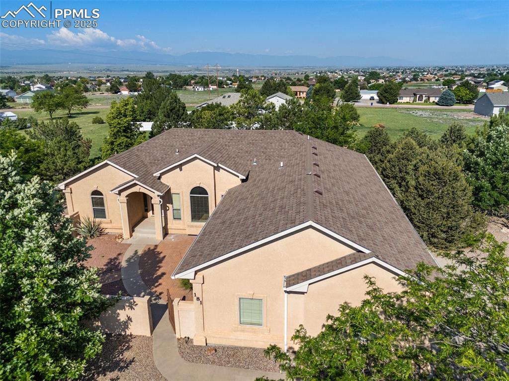 Charming ranch-style home in Liberty Point, set on a beautiful acre of land. The lovely courtyard creates an inviting entrance. This home shows pride of ownership, with features like a formal dining room and a spacious primary suite, complete with a walk-in closet and a 5-piece bathroom that includes a garden tub and walk-in shower. The kitchen boasts stainless steel appliances, ample cabinet and counter space, a pantry, and a cozy nook with views of the lake. The split-bedroom design includes two additional bedrooms and a full bath. Natural light fills the home, and the family room and kitchen flow together perfectly for entertaining. The garden-level basement also brings in plenty of light. Enjoy the expansive deck with views of the Pueblo Reservoir and the mountain range. Mature landscaping enhances both the front and back yards.