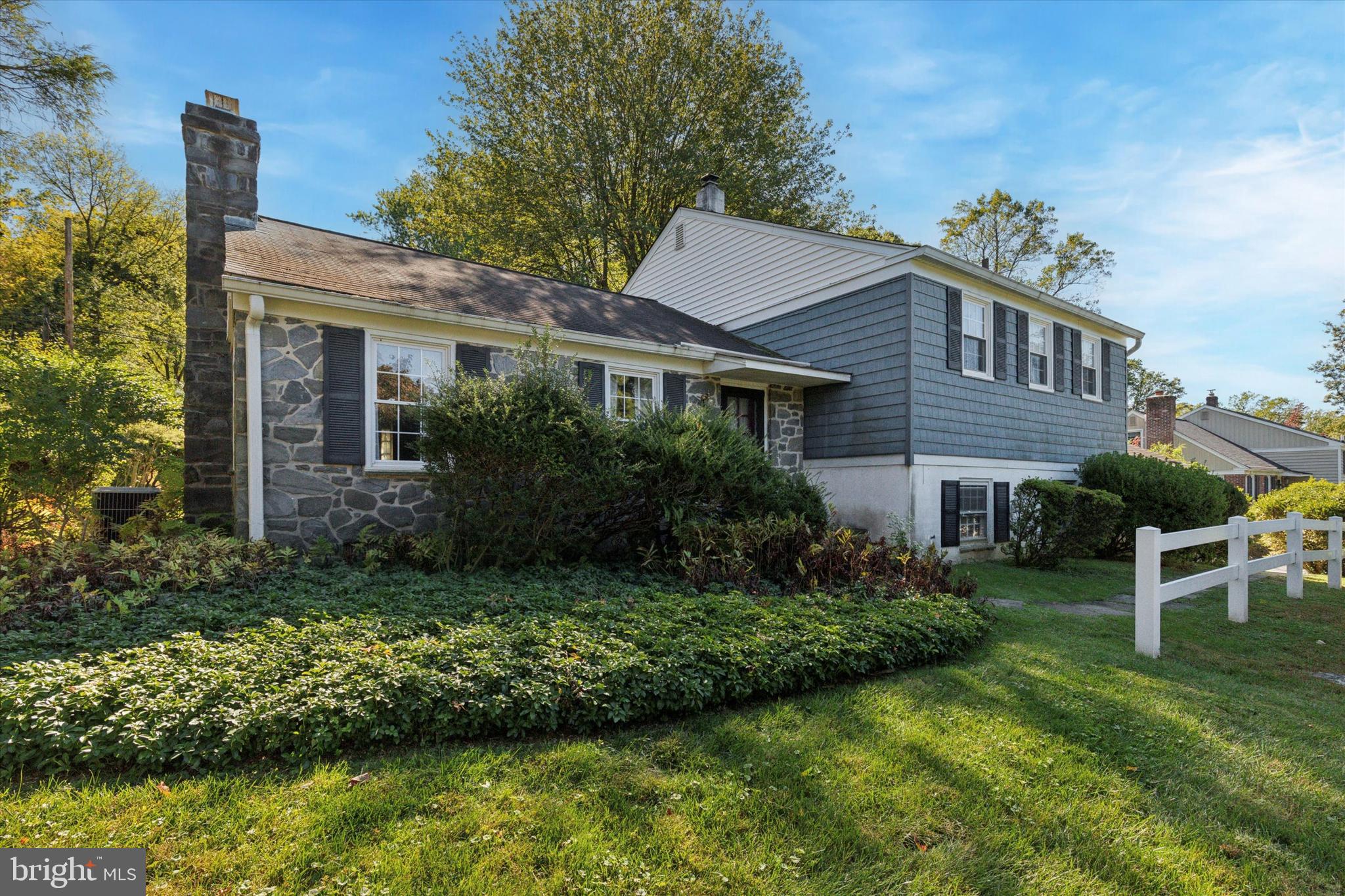 Welcome to 306 Devonshire Road, a classic split-level home tucked within the desirable Devonshire neighborhood of Tredyffrin-Easttown School District. Set on over three-quarters of an acre, this property offers a private and picturesque setting with a long, sweeping driveway and mature landscaping that enhances its curb appeal. Step inside to a spacious and sun-filled living room featuring a brick fireplace, built-in cabinetry, and large windows that bathe the room in natural light. The formal dining room showcases a centered chandelier, trendy wallpaper, chair rail detailing, and beautiful hardwood floors — the perfect space for entertaining or family gatherings.  The large kitchen offers abundant cabinetry, ample counter space, and an eat-in breakfast nook overlooking the scenic backyard. Down the hall, you’ll find three generously sized bedrooms, including one with custom built-ins. The primary suite features ample closet space and a private en suite bathroom, while a hall bath conveniently serves the additional bedrooms.  The finished lower level provides additional living space ideal for a family room, office, or play area, complete with a powder room for convenience. Step outside to enjoy the expansive paver patio, perfect for outdoor dining and relaxation, surrounded by lush, mature landscaping that offers both beauty and privacy. This home combines comfort, character, and location — just minutes from shopping, dining, and major routes.