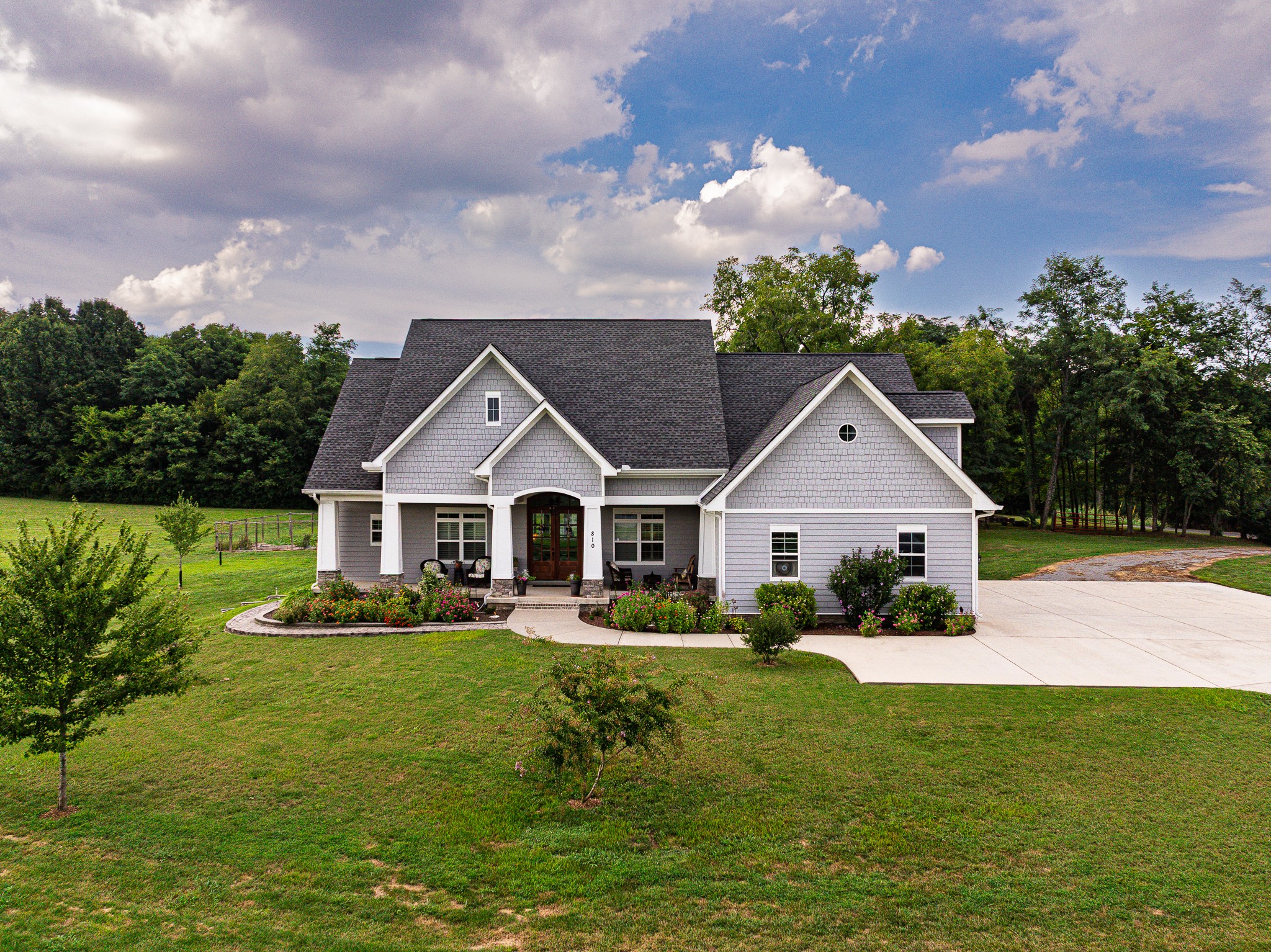 Welcome to your own private retreat—five scenic acres of freedom with no HOA or restrictions, in the Davidson County portion of Nolensville. Here, estate-level properties on acreage surround you—yet you’re just minutes from I-24, Historic Nolensville, and Brentwood via Concord Road. This custom-designed modern farmhouse, by architect Stephen Davis, delivers craftsmanship you can feel at every turn. Step inside to soaring spaces, curated finishes, and a layout built for today’s living. Right off the foyer is a great flex space that is currently used as an office. On the main level is the master bedroom and ensuite bath with separate vanities, 2 large walk-in closets with custom shelving from Container Store, and a large tiled shower. Also on the main level are 2 additional bedrooms, both ensuite and a laundry room complete with LG washer & dryer and a utility sink.  Upstairs is a bedroom, bathroom and bonus room. Lots of storage throughout this home.  The kitchen, with it’s 8’ x 5’ island (boasting storage on both sides), blends style and function with Pottery Barn lighting, double ovens, Bosch propane cooktop with pot filler, Z-Line vented hood, farmhouse sink, Bosch dishwasher, LG refrigerator, built-in wine cooler, and soft-close cabinetry with clever storage touches. Gather around the stone fireplace, unwind on the insulated screened porch with high ceilings, or grow your own vegetables in the 1000sf garden with 5 raised beds—and room for more. The oversized 800sf garage with utility sink, plantation shutters, whole-house surge protector, encapsulated crawl space with commercial dehumidifier, and dual Trane HVAC systems add comfort and peace of mind. A 5-bedroom septic system provides flexibility for the future. With agricultural/residential zoning, this property welcomes animals, gardens, or even horses. Outdoor living is enhanced with a paver walkway, retaining wall and plentiful electrical outlets. This is more than a house, it’s a lifestyle of space & privacy