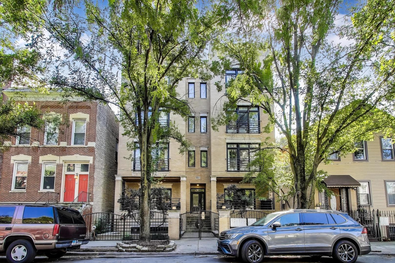 Discover the charm of Noble Square, positioned in a prime location bridging West Town and Wicker Park. 1455 W Thomas, #2E is a spacious 3-bedroom, 2-bath simplex condo in a boutique all-brick building on a tree-lined street. The kitchen features white cabinets, a custom hood, quartz countertops, stainless steel appliances, and built-in wine rack. The open concept design seamlessly connects the kitchen, living, and dining areas, making it perfect for entertaining. Enjoy evenings by the gas fireplace, or gather around the large kitchen island with family and friends.    Refinished hardwood floors flow throughout the condo, leading into the primary bedroom, which comfortably accommodates a king-sized bed and dual nightstands. The primary suite includes a walk-in closet, spacious 19 x 11 private deck and ensuite bathroom - stone shower with body sprayers, separate whirlpool tub, towel warmer and a double-sink vanity. The second and third bedrooms are generously sized with large closets, providing flexibility for a guest room, nursery, or home office.     For commuters, this location is unparalleled, offering access to the Division Blue Line, multiple bus routes (Ashland, Milwaukee, Division), and convenient proximity to I-90/94 and I-290.       This unit includes attached heated garage parking and a large walk-in storage closet. Fresh 2025 updates include a new kitchen backsplash, pendant lighting, kitchen faucet, and dual faucets in the primary bathroom. The HVAC, water heater, and bedroom carpet were updated in 2020.