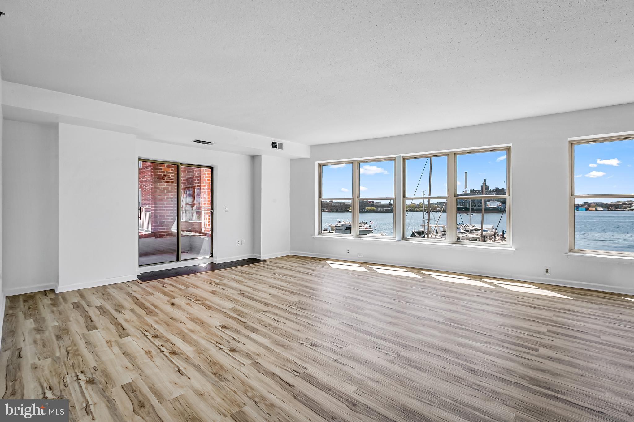 Rare rental offering for a Fells Point direct waterfront condo with parking and extensive building amenities in Belt’s Landing.  This fabulous 2 bedroom, 2 full and 1 half bath residence boasts 1650  sq. ft. of premium urban living space with an additional 80 sq. ft. of covered balcony. Features include: a dramatic living/dining floor plan with a wall of windows capturing spectacular Harbor and city scape views, updated kitchen cabinetry and appliances, en-suite large primary bedroom with two walk-in closets and spacious bath with double sink vanity, tub and separate shower stall, second bedroom with water views and second full hall bath, convenient powder room, and stacked washer/dryer. The condo has been enhanced with handsome deluxe vinyl plank flooring throughout, designer lighting fixtures,  neutral paint, and replacement windows.  The balcony adjoins the brick courtyard and is perfect for casual dining or enjoying the amazing panoramic views. Two garage unassigned parking spaces are included.  Belt’s Landing is a full service condominium building in the heart of Fells Point.  Building amenities include: 24 hr. front desk staffing, security cameras, outdoor pool overlooking the Baltimore Harbor and promenade, exercise/community room, elegantly appointed lobby, smoke detectors and sprinklers. The building is located within steps of the Belt’s Wharf Landing Marina and Yacht Club, and within proximity to downtown Baltimore, Harbor East, Harbor Point, Johns Hopkins and U of M campuses, various institutions and major highways.  Shopping, cultural activities, restaurants, and bars are all within walking distance.  Applications should be made through Rent Spree. Tenant responsible for elevator move-in and move-out fees.