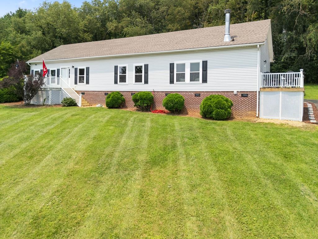Meticulously maintained and beautifully updated, this exceptional one-level home offers 1,976 square feet with 4 bedrooms, 3 full bathrooms, and 2.18 scenic acres. From its elevated setting, enjoy scenic views of the surrounding area, while the private backyard offers a peaceful retreat surrounded by mature trees. The current owners have thoughtfully updated nearly every room, creating a home that feels fresh, inviting, and truly move-in ready. The heart of the home is the beautifully updated kitchen, featuring custom cabinetry, quartz countertops, stainless steel appliances, a center island with seating for four, and abundant workspace. Throughout the home you'll find luxury vinyl plank flooring, new carpet, remodeled bathrooms, updated window treatments, new ceiling fans/lights, and fresh finishes. Nine-foot ceilings and a welcoming foyer enhance the home's open, airy feel, while walk-in closets provide exceptional storage. A dedicated laundry room, replacement windows with a transferable lifetime warranty, and a 2019 HVAC system offer added convenience and peace of mind. Two wood-burning fireplaces complete the spacious floor plan. A rare feature of this home is its two private primary suites, each with its own full bathroom—ideal for multigenerational living, extended guests, or added privacy. The main primary suite includes a freestanding soaking tub and a generous walk-in closet. Step outside to your own private backyard retreat, where an updated deck overlooks mature shrubs and a tree-lined backdrop. The 2.18-acre property also features a paved driveway, room for gardening and outdoor activities, fruit trees, and two storage buildings. Offering the perfect blend of space, quality updates, privacy, and scenic views, this remarkable home is ready to welcome its next owners. This is a home that simply must be experienced in person to fully appreciate all it has to offer. Perhaps the only thing this home is waiting for... is you.