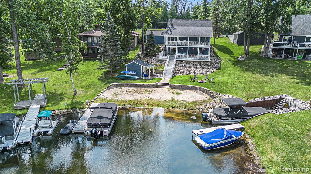 Enjoy lake life year-round in this 3-bedroom, 2-bath waterfront home on all-sports Lake Ogemaw with 77 feet of frontage! Inside, you’ll find a bright, airy atmosphere with a neutral palette, beautiful flooring throughout, and large windows that frame stunning water views. The living room features vaulted ceilings and a cozy fireplace, while the kitchen offers stainless steel appliances and plenty of space for cooking and gathering. Both bathrooms are finished with gorgeous tile work, adding a touch of style and comfort. Outdoor living is easy with a spacious deck, covered porch/balcony, and multiple outbuildings that provide ample storage for all your lake gear.