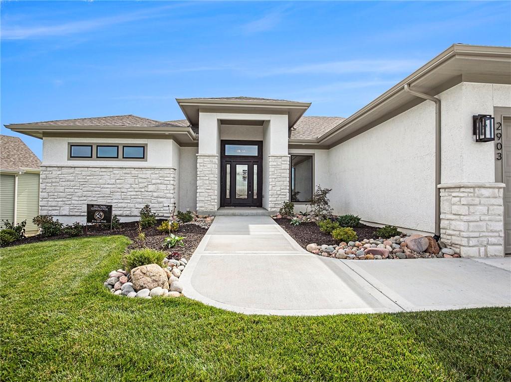 Welcome to your dream retreat in the prestigious Staley Farms community of Kansas City. This stunning single-family residence boasts a captivating blend of modern elegance and cozy comfort, perfectly situated in one of the city's most sought-after neighborhoods.

Step inside this reverse 1.5 story home and experience luxury at every turn. With 4 bedrooms and 3.1 bathrooms spread across its spacious floor plan, there's ample room for both relaxation and entertainment.

As you explore the lower level, you'll discover a walk-out design that seamlessly connects indoor and outdoor living spaces, creating the perfect setting for gatherings or quiet evenings under the stars. The wet bar adds a touch of sophistication, while custom cabinetry and warm earth tones throughout evoke a sense of timeless charm.

Elevated lighting fixtures illuminate the home's refined features, while tall ceilings and wooden beams lend an air of grandeur to the main level. Picture-perfect windows flood the recreational room with natural light, creating a bright and inviting atmosphere that's sure to impress.

For added convenience, the laundry room is thoughtfully located off the primary walk-in closet, making daily chores a breeze. Step outside from the primary bedroom onto the covered deck, where you can savor your morning coffee or unwind after a long day, surrounded by the tranquility of your private retreat.

With its exceptional craftsmanship and attention to detail, this home offers the perfect blend of style and functionality for the discerning buyer. Don't miss your chance to make this Staley Farms gem your own – schedule a showing today and experience luxury living at its finest.