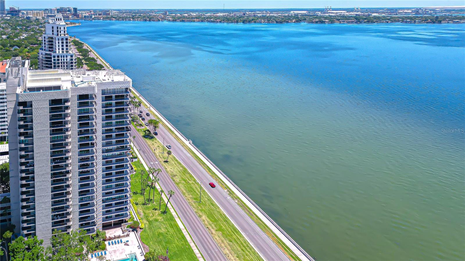 Perched high above one of Tampa's most celebrated addresses, this impeccably appointed residence at the Atrium on Bayshore offers a rare convergence of sweeping open-bay panoramas, refined interior finishes, and a building that has been comprehensively reimagined from the ground up. From the moment you step inside, the seamless open floor plan draws your gaze outward toward the glittering waters of Tampa Bay, the iconic Bayshore Boulevard promenade, the enchanting skyline of Davis Islands, and the luminous towers of downtown Tampa, a living canvas that changes with every hour of the day. The great room flows naturally to an oversized wrap-around balcony, an entertainer's stage designed to capture every angle of the breathtaking scenery that surrounds the building. Newly installed PGT WinGuard hurricane-impact sliding doors provide seamless access to the balcony while delivering exceptional storm protection and year-round peace of mind. Inside, the chef's kitchen has been thoughtfully curated with rich solid-wood cabinetry, gleaming granite countertops, a full suite of stainless steel appliances including a new dishwasher (2024), and a breakfast bar that invites leisurely mornings above the bay. The primary suite is a private retreat complete with a gracious en-suite bathroom appointed with beautiful designer finishes and a generous closet with a custom organization system. The guest bedroom and bath are equally well-appointed. Crown moldings, wide-plank flooring, full-size in-unit washer and dryer round out a truly turn-key residence. Simply arrive and begin living. What further distinguishes this offering is the extraordinary level of capital reinvestment the Atrium has recently undergone, all fully funded through a completed seller assessment, meaning the incoming owner inherits every benefit with zero financial obligation. Improvements include a brand new roof, a whole-building natural gas generator, full balcony waterproofing, a refurbished covered garage, and brand new tennis and pickleball courts coming soon. Building amenities include 24-hour security, an on-site property manager, a pool and spa overlooking the water, a fitness center, a recreation room with a kitchen, and a library. The unit also conveys two assigned covered parking spaces plus bike storage. Beyond your front door, the lifestyle is equally remarkable. Walk to the vibrant dining and boutiques of Howard Avenue, cycle miles of the beloved Bayshore Boulevard waterfront path, or venture minutes to Hyde Park Village. A-rated schools, convenient access to downtown Tampa, Tampa International Airport, and Tampa General Hospital complete this exceptional address. A residence of this caliber, beautifully renovated, comprehensively updated, and with all assessments fully settled, is an exceedingly rare find on Bayshore Boulevard.