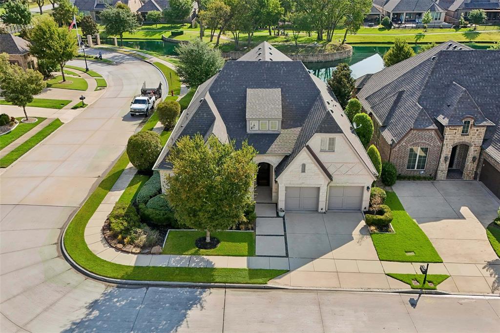 A rare opportunity to own an exceptional former model home where elevated design, thoughtful upgrades, and effortless single-story living come together in sought after gated Heron Pond. Ideally positioned on an oversized corner lot, this beautifully appointed residence makes a striking first impression with extensive lush landscaping, a handsome stone facade, and a front-entry 3 car tandem garage. Inside, rich hardwood flooring, abundant natural light & designer details create a sophisticated yet inviting atmosphere. Two spacious guest bedrooms offering a split setup for everyone’s comfort. The office features double doors, a decorative fireplace focal point & a large closet for storage or it could be a fourth bedroom. At the heart of the home, a grand open-concept living space is designed for both luxurious everyday living and memorable entertaining. A dramatic chandelier and floor-to-ceiling stone fireplace anchor the living room, while expansive sliding glass doors open to the outdoor living area, creating a seamless connection between indoors and out. The stunning kitchen is equally impressive with an oversized granite island, pendant lighting, gas cooktop, double ovens, abundant cabinetry & extensive counter space. A light-filled breakfast nook captures beautiful backyard views. Private primary suite is a true retreat, featuring bay windows, direct patio access & a luxury bath with dual vanities, a soaking garden tub, oversized WI shower & beautifully designed custom closet. Even the utility room has been thoughtfully elevated with a sink, BI cabinetry & dedicated space for an additional refrigerator. Outdoor living is equally exceptional. An expanded covered patio overlooks the neighborhood lake, offering a picturesque setting for entertaining, dining outdoors, or unwinding at the end of the day. Turfed backyard provides a polished, low-maintenance finish. Additional upgrades include a 2024 roof, whole house generac generator + an electric garage storage lift.