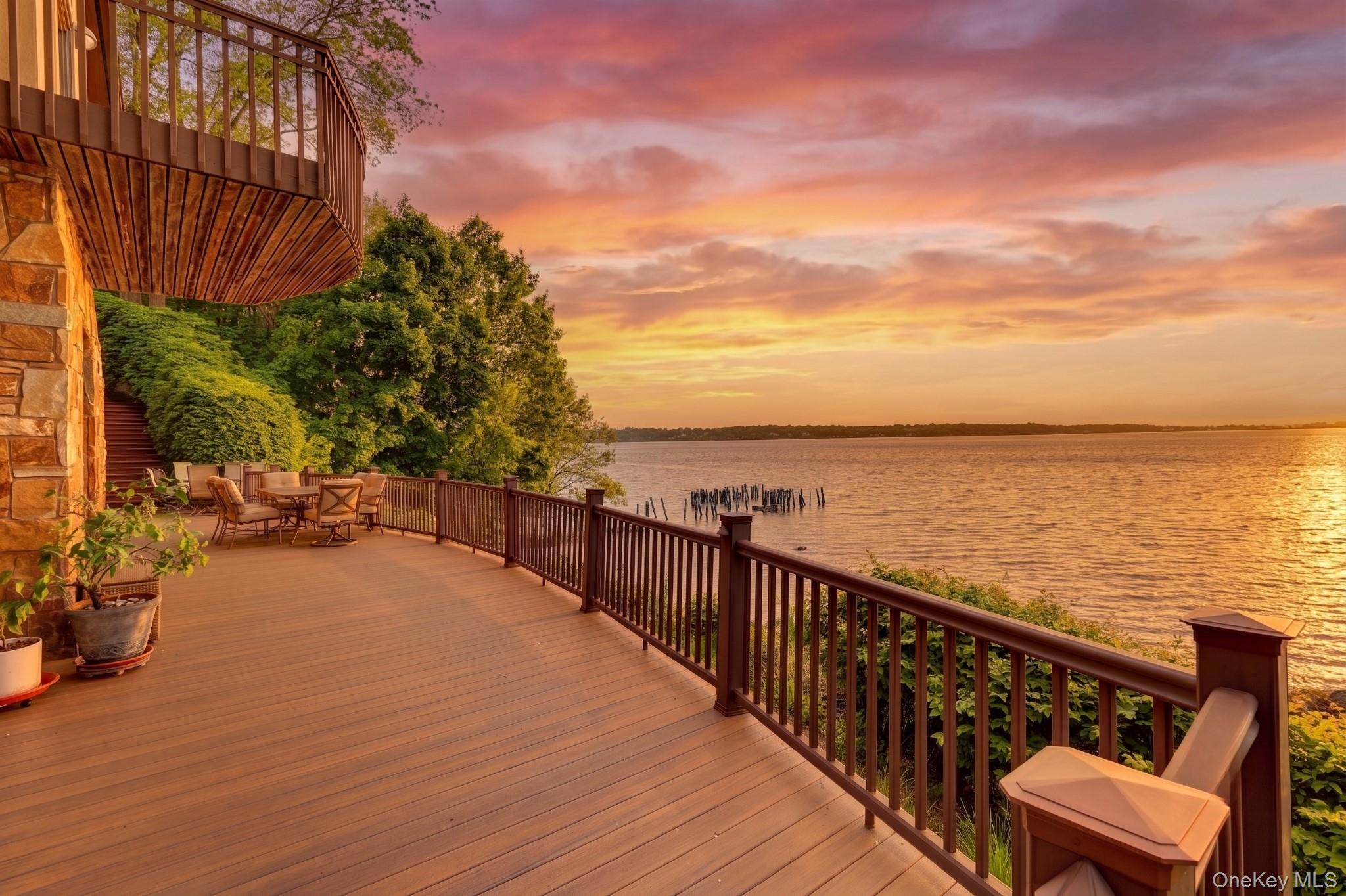 Sunset lovers rejoice! Secluded at the end of a private drive, this diamond condition waterfront masterpiece offers a rare synthesis of architectural grandeur and coastal serenity, where 150 feet of direct beachfront serves as your own personal sanctuary. Built in 1990 and meticulously maintained, the residence spans three sophisticated levels of living space, each thoughtfully oriented to capture unobstructed, sweeping views of the Sound. The heart of the home is defined by soaring two-story windows that bathe the interior in natural light and frame the dramatic, west-facing sunsets that paint the sky every evening. With five spacious bedrooms and five bathrooms, the home provides an unparalleled retreat. Culinary enthusiasts will appreciate the high-performance natural gas cooking and heating, while the newly installed whole-house generator ensures absolute peace of mind regardless of the season. Situated 30 foot above sea level, the home’s interior transitions seamlessly to expansive Trex decking, offering durable, low-maintenance outdoor spaces to enjoy and entertain. Beyond the main residence, the two-car garage is topped with a versatile studio, providing the perfect professional environment for a home office or guest suite. The lower level has its own entrance and could operate as another 3 bedroom, 2 bath separate living space. Lifestyle is at the forefront of this property, as residents benefit from dual homeowners associations that provide a luxury resort experience, including access to a private pool, tennis and pickle ball courts, mooring rights and an exclusive beach. Perfectly balancing the feeling of being worlds away with convenient access to local amenities, this grand home represents the pinnacle of waterfront living.