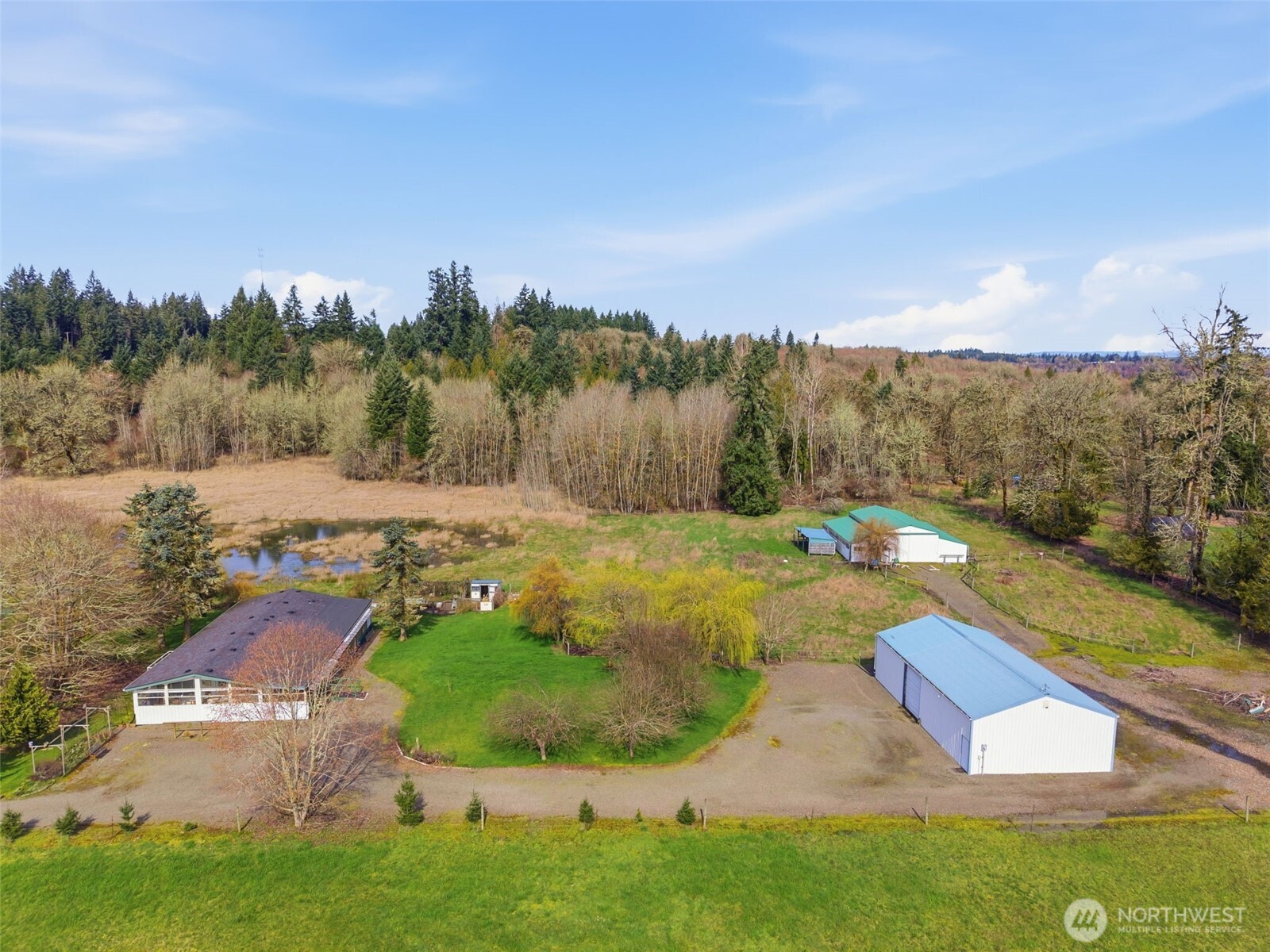 Experience the perfect blend of country living and convenience on this 4.8-acre property. This 1,568 sqft home features 2 bedrooms, 2 baths, a den/office, vaulted ceilings, and a classic wrap-around covered porch. Hobbyist and equestrian-ready, the grounds include a 2-bay shop and a 4-stall barn complete with mats, a tack room, and hay storage. This partially fenced acreage offers a rare balance of rural privacy and effortless I-5 access—schedule your private tour today before it’s gone!