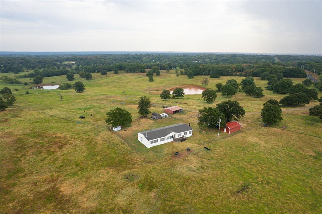 Picturesque, scenic views of pasture, trees and farmland with the house sitting atop a hill - this could be your new home! Property is located in unincorporated Cleveland County (outside city limits = Norman mailing only; Noble schools). This property will be selling with 10 acres, but ask about the other 20 acres the seller also has available that includes a pond (MLS #1244630)! The home is a 2010 Clayton Homes model that opens up into the biggest open space perfect for all your friends and family to gather. Walk in the front door to the den and then the formal dining room. A convenient corner built-in office/study area is right next to the laundry room (Laundry is completely hidden and looks like additional cabinetry when doors are shut.). The large kitchen includes an island with lots of bookshelf space and storage and the breakfast dining area. The main living room is connected, complete with a wood burning fireplace. On the other side of the house are the bedrooms. There are two guest bedrooms with a full bathroom in between. The master suite includes a sitting room or office space. The master bathroom has a corner garden tub, separate shower, double sinks and lots of room for moving around and storage. You even have your own back door leading to a private covered porch off of the master bedroom! New Hot Tank just installed. The whole property was used as a cattle farm and is fully fenced around the full 30 acres the seller owns. Pasture has been well worked over and graded and divided into 3 total sections. The ten acres with this listing includes the 10x18 shed with loft, the open barn (electric is run to it and solar lights), and the 2-car detached garage with a 3rd bay for storage. Property is on a septic (new 2010) and a spring-fed well (pressure switch and tank recently replaced; plenty of water spigots surrounding the house, barns). High speed internet is available. Call to schedule your private tour of this beautiful property!