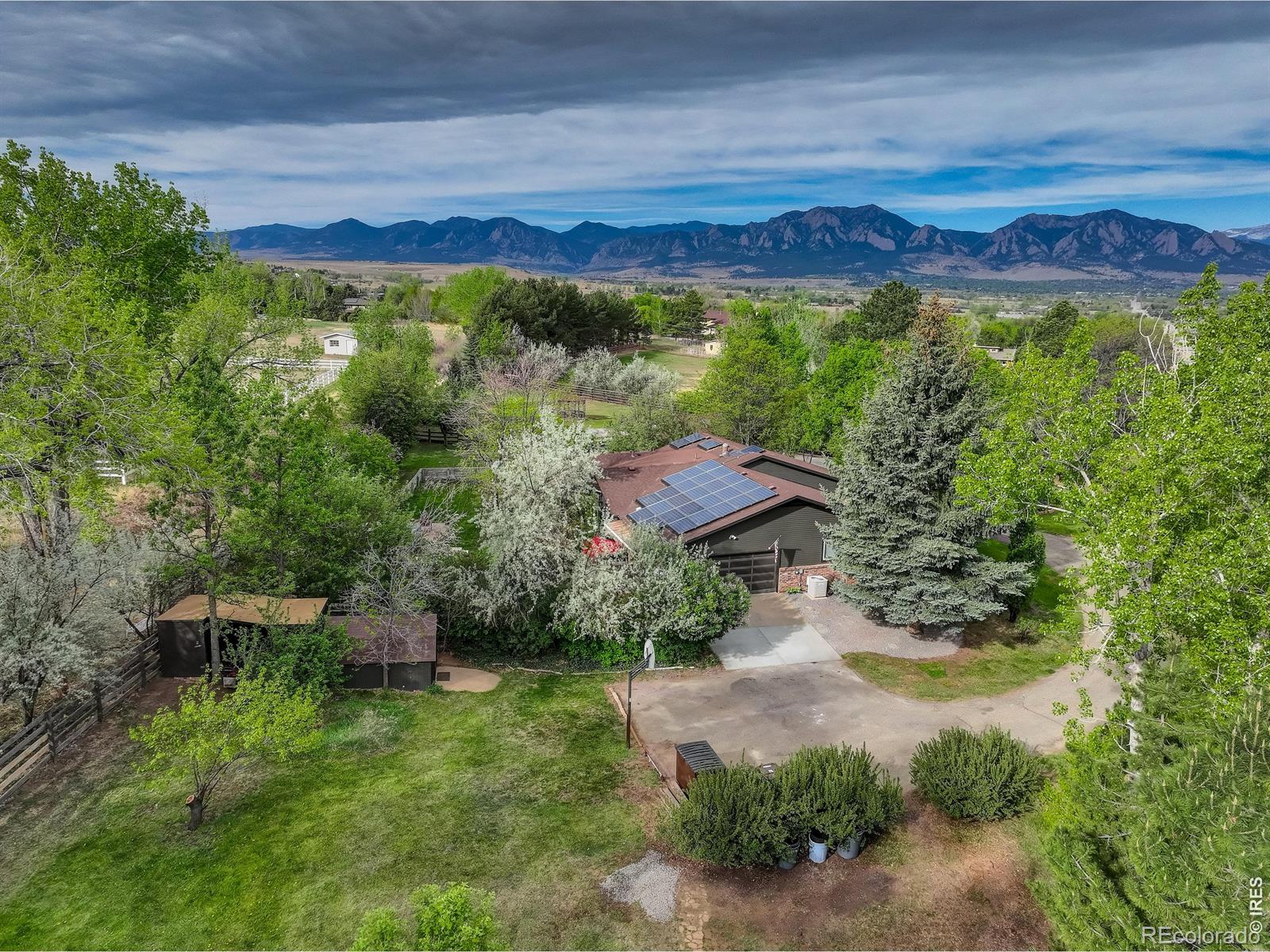 A rare opportunity awaits in highly sought-after Paragon Estates. This expansive 1.46-acre property is a true sanctuary, featuring vibrant blooming foliage, mature deciduous, pine and fruit trees, with sweeping mountain views stretching from north to south. Enjoy exceptional outdoor living with multiple entertaining areas, raised garden beds, two gazebos, a hot tub, and a built-in firepit. In addition to the sprawling 3,800-sq-ft ranch home, the property includes a newer main-floor, two-bedroom ADU (+720 sf)-ideal for guests, multigenerational living, or rental income. Reap rewards during the '27 Sundance Film Festival in Boulder! Inside the main residence, experience easy, comfortable living with 5 bedrooms, 3 baths, a variety of formal and informal gathering spaces, open floor plan, and a spacious chef's kitchen. Skylights and thoughtful architectural details enhance the home's unique, warm, inviting atmosphere. Upgrades abound: newer flooring, hot-water radiant heat, solar panels, a welcoming front porch facing Long's Peak, multiple decks, patios, a custom bar in the game room, two stunning built-in aquariums, abundant indoor and outdoor storage, and an oversized two-car garage with additional outside parking for multiple vehicles or an RV. Have an equestrian companion? This property welcomes hooves. This spring, come home to sunsets, views, seclusion, and peaceful moments in your own slice of Colorado heaven.