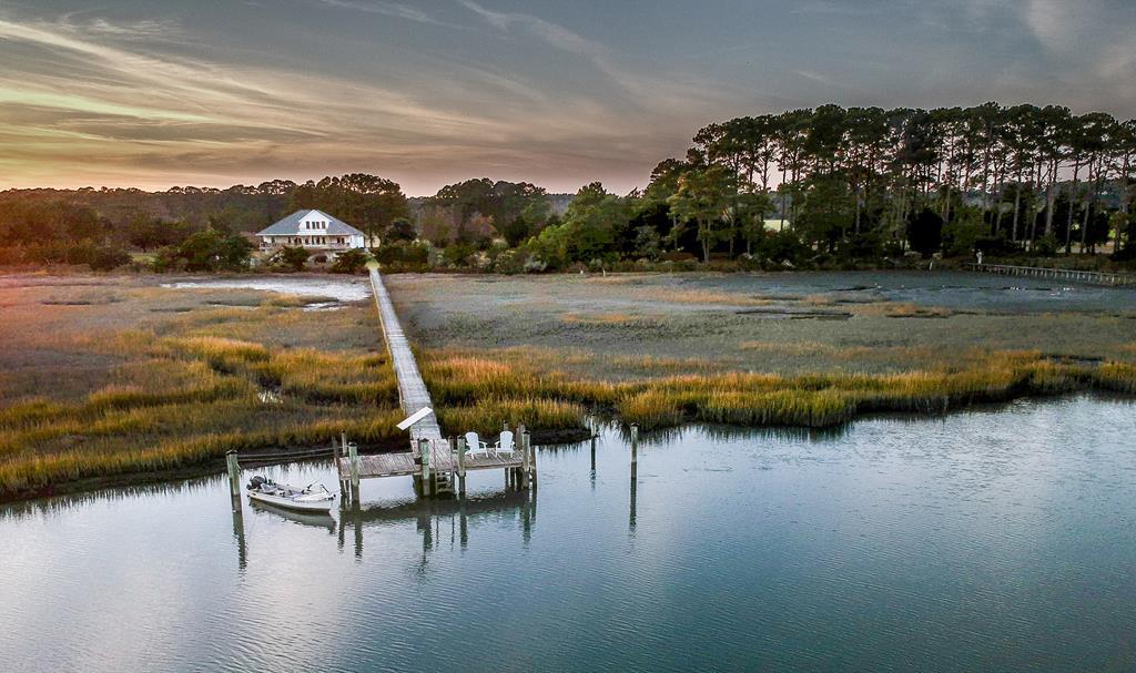 Experience turnkey coastal luxury at its finest in this 3BR, 2.5BA custom residence offering over 3,100 sq ft, with hurricane shutters and upgrades. Privately situated on a secluded 6-acre peninsula at the end of a quiet road, the home features 360-degree water views, including panoramic vistas of the Atlantic Ocean. Enjoy direct access to the Barrier Islands and the Atlantic and immerse yourself in North America's last truly unspoiled coastal region, designated as an International  Biosphere Reserve by the United Nations.Savor world-class fishing, crabbing, oystering, clamming, and wildlife viewing just steps from your door. Designed for effortless elegance and year-round enjoyment, the home includes a gourmet chef's kitchen, flexible living space, private office, workshop, garage