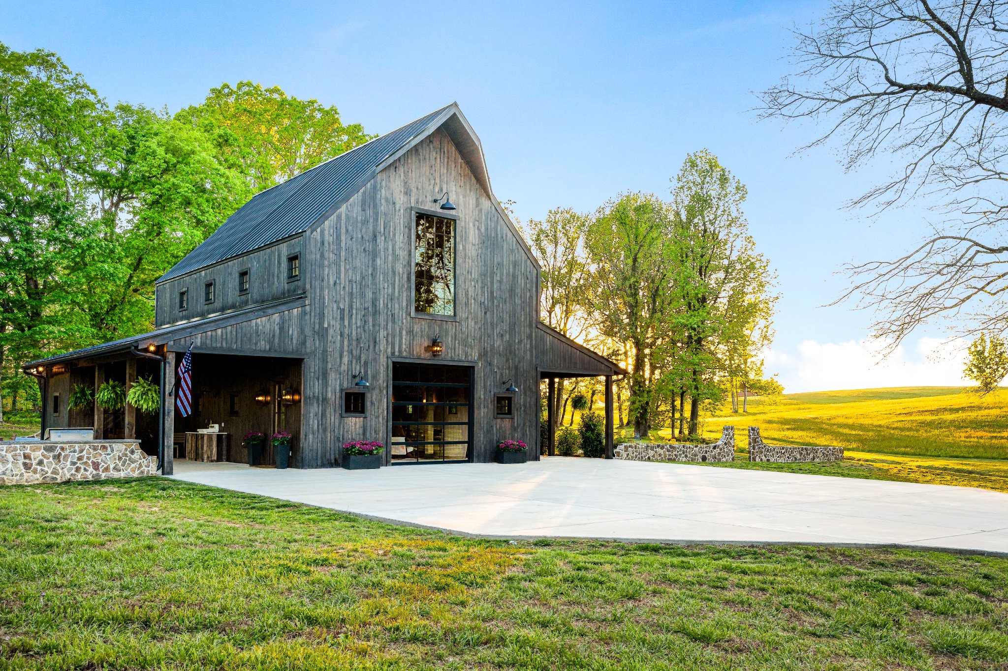 Just outside the Dickson city limits, this property features 14.5 acres of exquisitely maintained TN countryside, full of natural beauty and privacy. At the crest of the gently rolling topography, a spectacular build site awaits, approved for a 5 bedroom home, perfect for building your TN legacy estate.Tucked beyond the picturesque stream to the rear of the property sits the custom-built modern barn house, a thoughtfully built and beautifully curated space with luxurious finishes. Once inside, you will notice the attention to detail, from the white oak tongue and groove walls to the cypress ceilings and wood and stone accents throughout. The lower-level bonus area features 12-foot ceilings, concrete floors and would make an incredible space for a wedding venue, music writing retreat, multigenerational living or guest accommodations. Upstairs is an entertainer’s paradise featuring multiple seating areas, loft area, bedroom, laundry and full bath, gorgeous kitchen with 6 burner gas stove, quartzite island and gas stone fireplace. The floor to ceiling window offers a spectacular view of this exquisite property. Outside is complete with an outdoor kitchen, stone fireplace and plenty of room to have family dinners in the summertime. The other side of the barn offers a rocking chair porch, where you can watch the kids roast smores in the firepit, while watching the sun set over your private acreage. This property is perfectly situated an hour from Nashville, Franklin and Leiper’s Fork, and ready for your imagination. The property is thoughtfully developed, with over 1000 feet of underground electric, natural gas lines run to the barn and a 12 feet wide, 1000-foot gravel road system. This property is surrounded by large tract neighbors, including a land trust property directly behind the property, ensuring privacy and lasting beauty for generations.