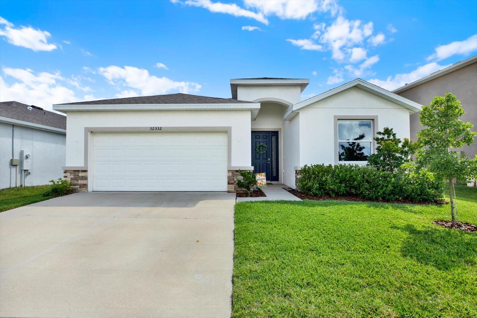 WOODCREEK in Wesley Chapel! Why wait for new construction? This move-in-ready Lantana floor plan offers comfort, space, and style, and best of all, it is AVAILABLE NOW. The thoughtfully designed one-story layout features 4 bedrooms, 2 baths, and a split floor plan for added privacy. Enjoy an open-concept kitchen with granite counters, stainless steel appliances, and a large island that flows into the spacious living area with ceramic tile throughout the main spaces. The primary suite includes dual walk-in closets, dual sinks, a separate soaking tub, and a stand-alone shower. Relax on your covered lanai overlooking a peaceful pond and conservation view with NO FRONT OR REAR NEIGHBORS. Just a quick walk or roll to the community pools, playground and amenity center. Located in the sought-after Wesley Chapel area, zoned for top-rated local schools, and just minutes from shopping, dining, and major commuter routes. A rare opportunity to own the popular Lantana model without the wait. Schedule your showing today.