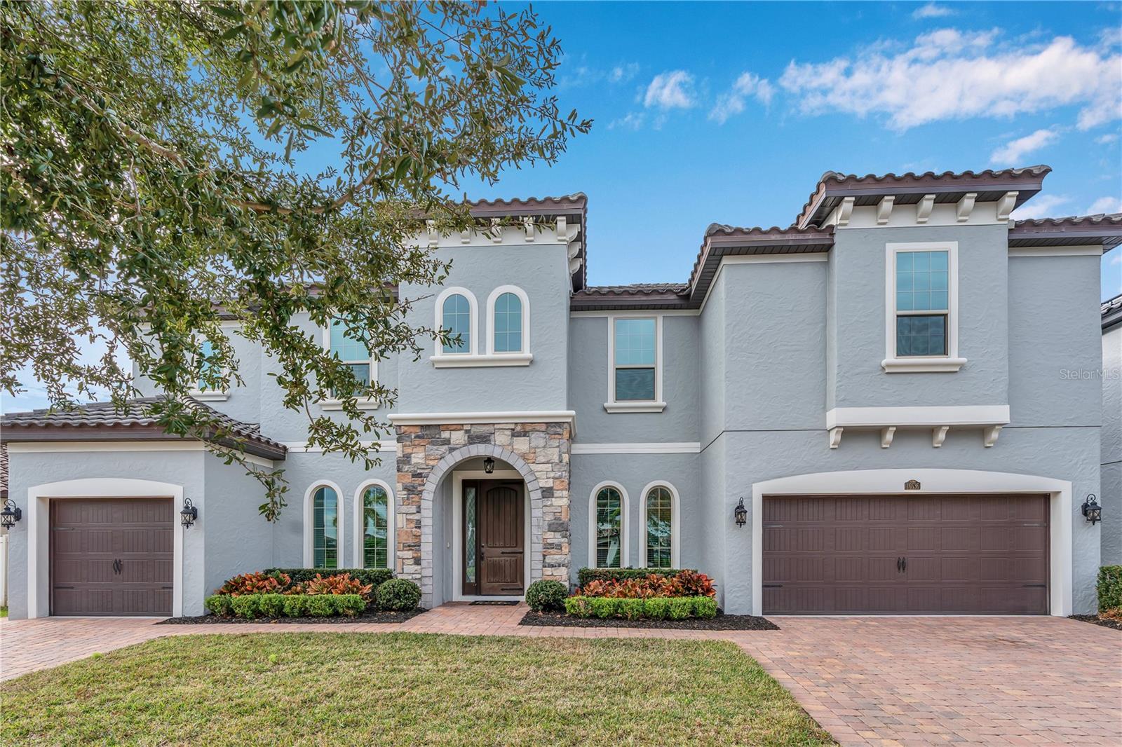 Under contract-accepting backup offers. Set within Winter Garden’s desirable Twinwaters community, this expansive residence blends Mediterranean-inspired architecture with modern comfort, energy efficiency, and thoughtful upgrades throughout. Offering 5,177 square feet of living space and 6,132 total square feet under roof, the home provides six bedrooms, five full bathrooms, generous gathering areas, and an outdoor setting designed for privacy and relaxation.A stone-accented entry welcomes you into light-filled interiors where tall ceilings and open living spaces create a natural flow throughout the main level. At the heart of the home, the upgraded kitchen features premium KitchenAid appliances, extensive quartz counter space, abundant cabinetry, and a layout that streamlines both everyday living and effortless entertaining. Retractable screens enhance the connection between indoor living spaces and the outdoors, allowing fresh air while maintaining year-round comfort. Two primary suites—one on each floor—offer unmatched flexibility for multigenerational living, extended guests, or a private retreat separate from the home's rhythm. Both suites include spacious bedrooms, well-appointed bathrooms, and generous wardrobe storage. New carpet elevates comfort on the second level, where additional bedrooms and a loft-style living area provide room for work, relaxation, or recreation. Thoughtful convenience continues with laundry rooms on both levels.The home prioritizes efficiency with a suite of meaningful upgrades. Fully paid-off solar power significantly reduces long-term operating costs, while WiFi-enabled thermostats provide precise climate control throughout. A new HVAC system installed in 2025 and energy efficient appliances enhances performance and peace of mind.Outdoor living is a central focus. A private luxury pool anchors the fenced backyard, creating a serene retreat bordered by manicured landscaping. The covered lanai extends the living space outdoors, and with retractable screens, it becomes a comfortable setting for dining, lounging, or gathering in every season.The property also features a distinctive three-car garage configuration, with a single-car garage on the left side of the home and a two-car garage on the right, offering flexible parking, storage, or workshop space. Mediterranean-style arched windows, a tile roof, and balanced architectural proportions contribute to strong curb appeal and timeless character.Positioned on a 0.20-acre lot, the residence benefits from a well-established community known for convenient access to top-rated schools, parks, trails, shopping, dining, and the vibrant lifestyle of Downtown Winter Garden and Horizon West. Major roadways connect the area to Orlando’s business, medical, and entertainment centers, offering a lifestyle that is both refined and practical.With its impressive scale, versatile layout, energy-efficient systems, and beautifully maintained condition, this Twinwaters home presents an exceptional opportunity to experience modern living in one of Winter Garden’s most desirable settings.