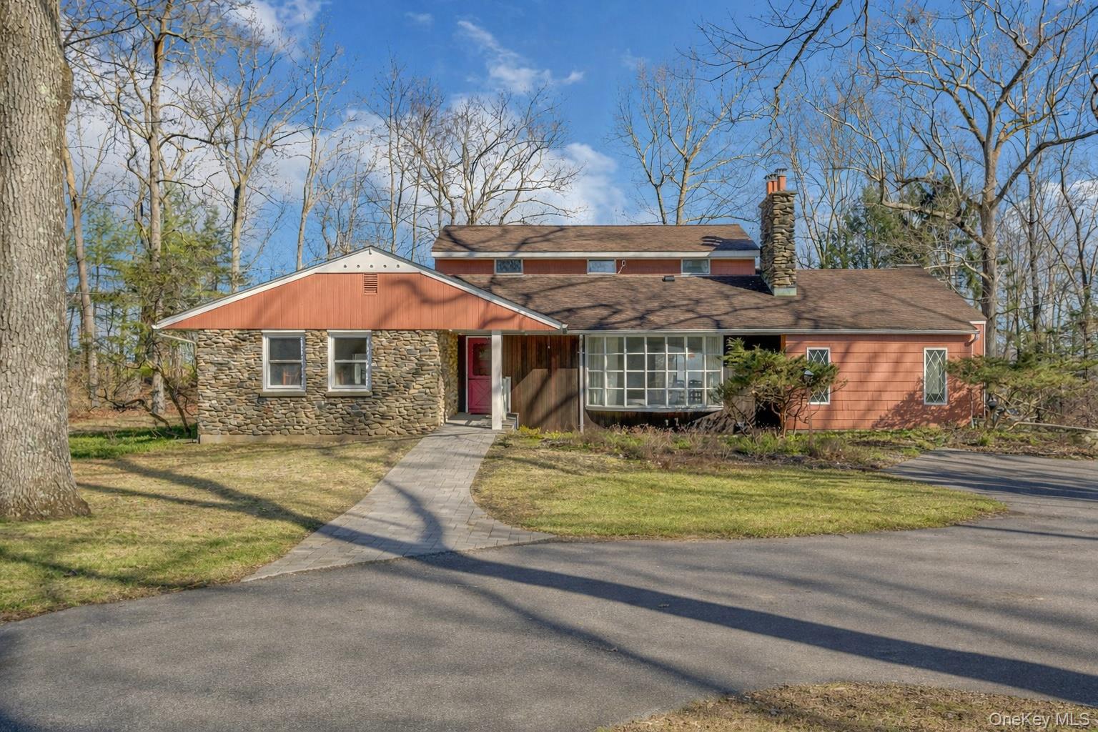 This is the kind of property people dream about! Set far back from the road down a long tree-lined driveway, this special retreat sits on over 3 breathtaking acres overlooking the Muscoot Reservoir—an extraordinary setting where nature, privacy, and wide-open skies take center stage. Start your mornings with coffee while listening to birdsong. Spend afternoons gardening or simply relaxing in the peaceful quiet of the surrounding landscape. Gather with friends, dine under the stars, and enjoy unforgettable nights of stargazing in this truly magical setting. Inside, expansive windows invite the outdoors in, filling the home with natural light and framing serene views in every direction. The welcoming living room features a beautiful picture window and a wood-burning fireplace with stone surround—perfect for cozy evenings. The flexible layout offers three first-floor bedrooms, including the original primary bedroom with en suite bath, along with the convenience of first-floor laundry. Upstairs, a spacious primary suite addition with walk-in closet, full bath and walls of windows provides a peaceful sanctuary.Perfectly located for both nature lovers and culture seekers, with nearby treasures including Muscoot Farm, Lasdon Park & Arboretum, Katonah Museum of Art, John Jay Homestead, and scenic hiking at Angle Fly Preserve. A rare opportunity to own an exceptional property where the views are inspiring, the setting is unforgettable, and every day feels like an escape to the country.  Come experience it for yourself.
