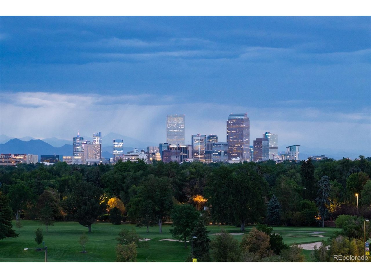Crowning Cherry Creek's most exclusive addresses, this penthouse offers over 5,000+ square feet where the creek below and mature trees along its banks lend unexpected serenity to city living - a home of presence, craftsmanship, and privacy paired with views seldom equaled in Denver. Enter a marble-clad foyer, black herringbone underfoot, light dancing from a trio of sculptural chandeliers. A dramatic double-sided fireplace divides the entrance from the grand living room beyond, where walls of glass rising  to the ceiling frame sweeping views of the Denver Country Club golf course, the Front Range, and the city skyline. Three private terraces extend the living experience: one off the primary suite, a room unto itself for quiet mornings and starlit evenings; one off the kitchen and dining area, perfect for al fresco entertaining; and one off the guest suite, blurring indoors and out. The kitchen showcases culinary mastery appliances such as La Cornue range, 2 Cove dishwashers, Subzero refrigerator/freezer/wine cooler and ice makers, Wolf microwave, quartzite countertops, adjacent wet bar, sunlit breakfast nook, and a modular island seating six. The adjacent dining room, anchored by a crystal chandelier, sets an elegant tone for gatherings large and small. The expansive primary suite offers a sitting area, couture dressing room, and spa-inspired bath with soaking tub, dual vanities, and steam shower, with a personal gym just off the bedroom. A split wing layout boasts an intimate private guest suite with full ensuite bath and walk-in closet. Steps away, a versatile bonus/bedroom with Murphy bed enhance the residence.  The architectural threshold guides you to a bespoke library and executive office. Building amenities include true valet service, 24-hour concierge, manicured gardens, 4 car spaces with underground parking, and on-site car wash. With fairway, city and mountain views as its backdrop, this is a rare opportunity in one of Denver's finest addresses. See Video