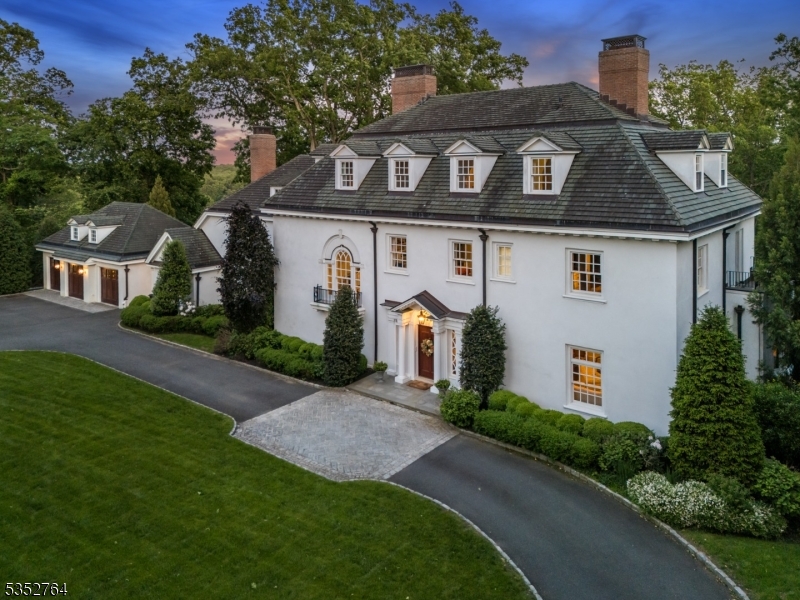 MASTERFULLY RESTORED HOME ON OVER AN ACRE, LESS THAN A MILE FROM DOWNTOWN SUMMIT! Welcome to 10 Rowan Rd, a stately circa 1910 Georgian Colonial w/ over 11,000 sq feet across 4 levels and including 8 Bedrooms/6.1 Baths, minutes from vibrant downtown Summit and NYC train. Exceptional privacy, backing onto Watchung Reservation w/ views of NYC skyline. Originally built by Philip Van Renssalaer Van Wyck and later owned by Adolph Root of Roots Department Store, a complete restoration has upheld its original charm w/ high-end touches to perfectly suit today's lifestyle. Impressive Grand Foyer sets tone for the First Level, rich hardwood floors, fluted columns, stacked crown molding, wainscoting, built-ins and impeccably restored windows. 11 fireplaces overall, each with a unique original mantle. Foyer, Great Room and Dining Room open to spacious Solarium w/ views of landscaped grounds with stone terraces, outdoor kitchen, and sports court. Dream gourmet Eat-in Kitchen w/ massive island, custom cabinetry, marble countertops, SS high-end appliances, 2 complete prep stations. Walk-in Pantry, Laundry & Mud Rooms, Wine Room, 3-Car carriage-house Garage meeting all needs. Sprawling Primary Wing offers Bedroom, 2 Baths, Sitting Room, 2 Walk-in Closets & bonus room. Additional 3 Beds/2 Baths. Third Level has 3 more Beds, 1 Bath & more. Lower Level stuns w/ Lounge, Gym, Recovery Room, Rec areas & Full Bath. This exceptional historic masterpiece is a must-see for today's discerning buyer!