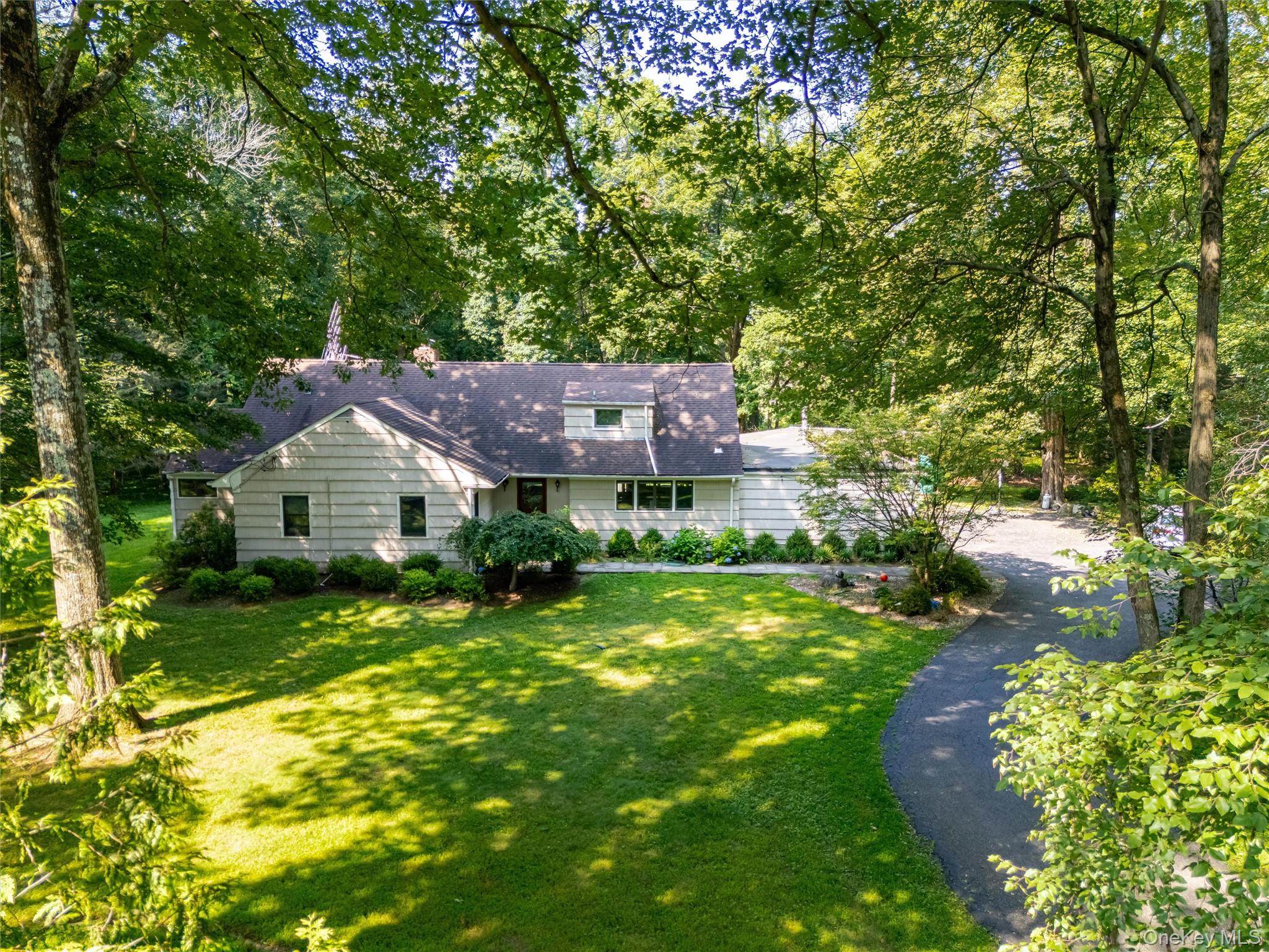 Tucked back on a private corner lot on one of Chappaqua’s most desirable and quiet streets, this expanded mid-century ranch offers a rare opportunity to create your dream home in an award-winning school district. The property is well situated on the lot, leaving plenty of space for a pool or future outdoor expansion.

Inside, the home offers a light-filled layout with generously sized rooms, walls of windows, and a natural flow between indoor and outdoor spaces. The kitchen opens to a large living and dining area anchored by a slate-surround fireplace and wide views of the level, park-like backyard. French doors lead to a deck and stone patio—ideal for relaxing or entertaining.

A spacious great room with wood-burning stove and powder room adds flexibility for everyday living. The main level also features an ensuite bedroom with glass doors to the yard, along with two additional bedrooms and a full hall bath. Upstairs, you'll find another bedroom, a full bath, a study, and a bonus room—offering a flexible layout that lives like a 5+ bedroom home.

The current owners have already begun the process of restoring and upgrading the home, and it’s ready for its next chapter. With potential for reconfiguration or expansion (with approvals), this is a smart value opportunity in a location where homes are rarely available at this price point.

Just minutes from the train, town, schools, Whole Foods, and Lifetime Fitness, this peaceful and private retreat offers convenience without compromise.