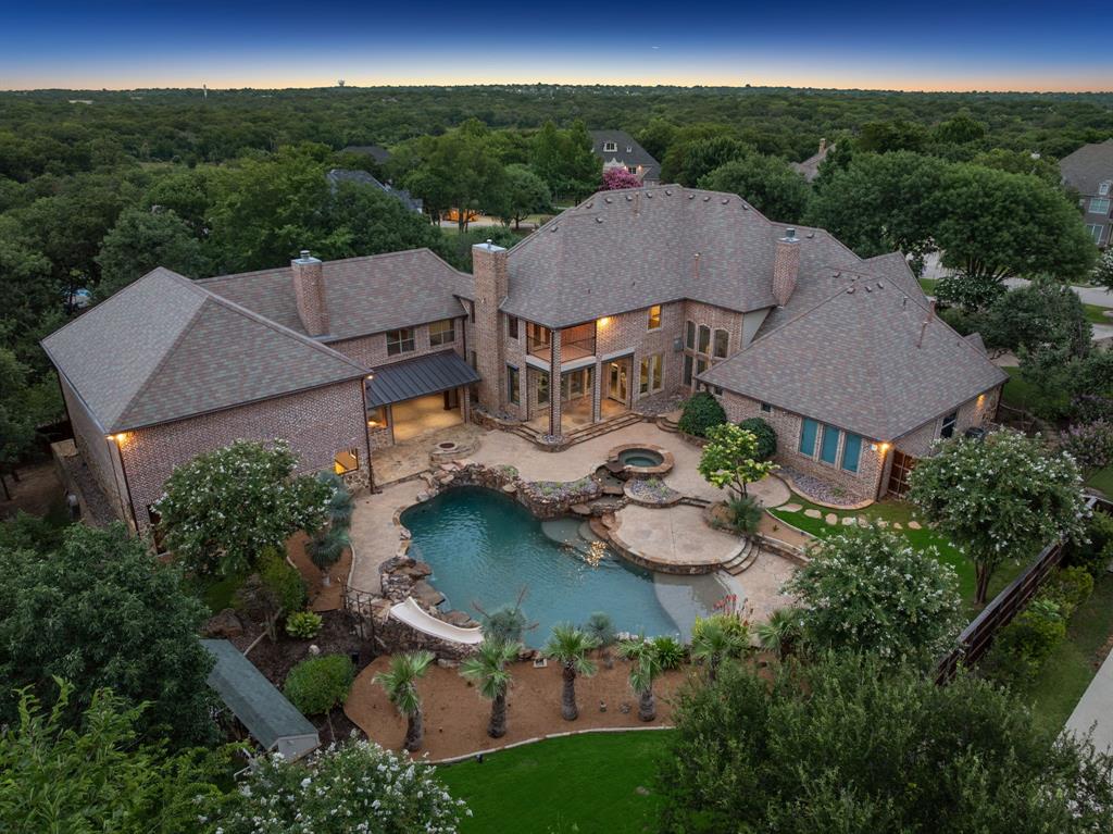 An amazing opportunity on this newly completed full-home remodel in the exclusive gated lake community of Point Noble. Situated on 1-acre private cul-de-sac lot, this 7-bedroom estate + separate apartment suite was thoughtfully reimagined for luxury living with everything today’s buyers are looking for. Added features include regulation indoor basketball gym with 3 adjustable hoops, electric scoreboard, and can second as a regulation volleyball or pickleball court. A fully equipped gym with current weight equipment, a large storage closet and bath that seamlessly connects to the indoor basketball court and the outdoors. Enter through double doors into a soaring 20-ft foyer with floor-to-ceiling windows framing the resort style backyard, where tiered pools, a hot tub, fire pit, covered veranda with outdoor kitchen, stone fireplace create an entertainer’s dream. A whole-home generator provides automatic backup power to the entire property, ensuring uninterrupted comfort.
Inside, newly refinished hardwoods flow throughout, a fully reconfigured chef’s kitchen equipped with new high-end appliances, oversized island + designer lighting. The primary suite emphasizes spa-like living with a freestanding tub beside fireplace, 11-ft deep steam shower, heated floors, coffee bar, full living room adjoining the sleeping quarters + separate dressing areas with ample storage including a hidden closet system. The home’s thoughtful layout features both upstairs + downstairs laundry, dual staircases, and on main level a private guest suite offers its own spacious walk-in shower + closet. Additional highlights include a recently installed slate roof, top-tier media room, wine cellar + dry bar, private office with bonus workspace, + additional exterior sport court, full interior paint update, and an upstairs screened porch. With room for additional 8 car parking, this home offers the perfect blend of privacy, luxury, and modern ease in one of the area’s most coveted lake communities.