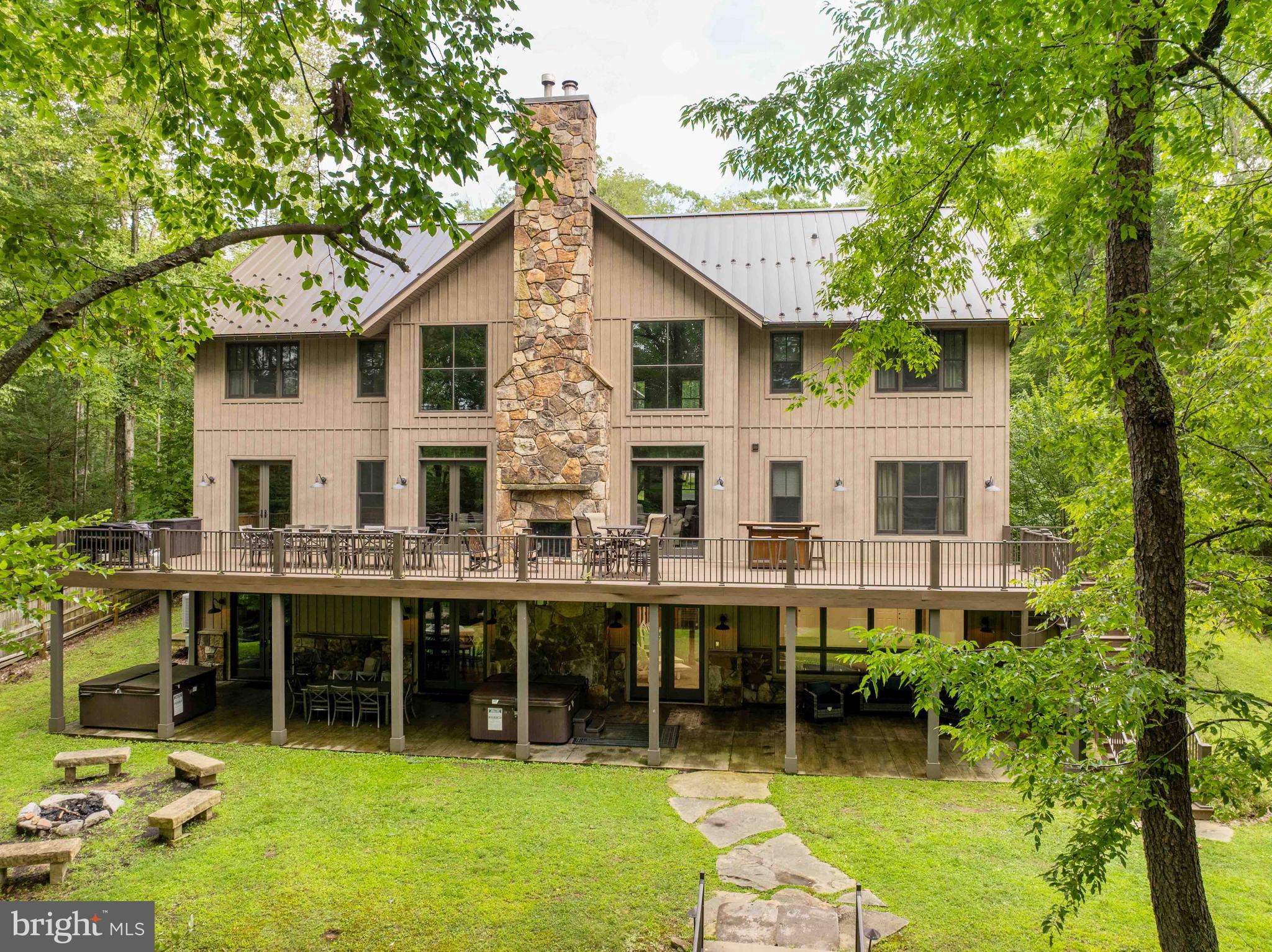 Experience exceptional lakefront living in this spectacular eight-bedroom estate designed for unforgettable gatherings and year-round enjoyment. Perfectly positioned on an oversized lakefront lot with  116’ LF, this remarkable home offers easy access to the water via a walking path, and the abundance of windows fill the interior with natural light.At the heart of the home is a magnificent great room with soaring ceilings, creating an impressive space for entertaining family and friends. The gourmet kitchen is a chef's dream, featuring premium finishes, generous prep space, and abundant cabinetry, making it as functional as it is beautiful.Boasting an indoor sparkling pool and sauna right off the lower-level family room, along with a full kitchen and a playroom. Then step outside to your private lakeside retreat, complete with two relaxing hot tubs, a fire pit area, a sports court in the front, and spacious outdoor living areas ideal for dining, entertaining, or simply soaking in the peaceful surroundings. With eight spacious en-suite bedrooms, there is ample room for guests, making this an exceptional primary residence, vacation home, or luxury rental opportunity “The Haven”.Offering the perfect blend of elegance, comfort, and resort-style amenities, this extraordinary waterfront property is a rare opportunity to own the ultimate lakefront lifestyle.