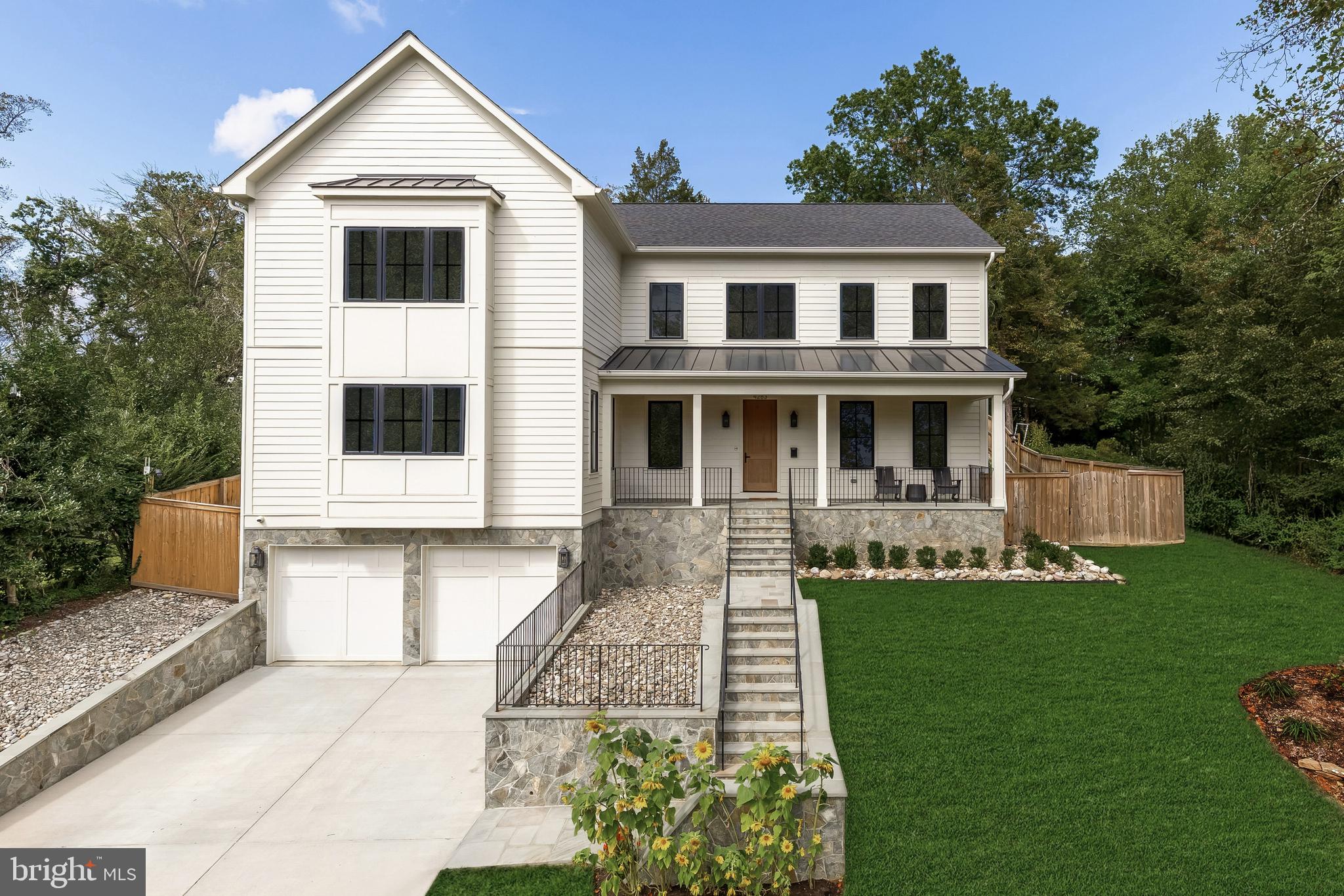 Tucked away on a quiet cul de sac in coveted Country Club Hills, 4283 38th Street North offers a rare blend of seclusion, sophistication, and striking design. Elevated above the street and framed by manicured landscaping, this custom residence was built in 2023 by CR Custom Homes and showcases where East Coast tradition meets West Coast style.The exterior merges the charm of a modernized Colonial with warm farmhouse influences. Interiors, curated by Santa Monica designer Tracy Gilmore, embrace a refined Southern California aesthetic. A broad stone staircase framed by tiered retaining walls leads to a welcoming front porch, setting the stage for elegance inside.A dramatic foyer, filled with natural light, spans the main level and highlights exceptional craftsmanship: wide plank white oak floors in herringbone, ten foot ceilings, eight foot quadruple hinged doors, Phillip Jeffries wallpaper, and motorized window treatments.Off the entry, a private study balances a main level bedroom suite ideal for guests or multigenerational living. The formal dining room, introduced by a refined vestibule, features a large bay window and connects via a butler’s pantry to the kitchen.At the center of the home, the kitchen is both showpiece and gathering space. Carrara marble wraps perimeter counters and backsplash, while a black leathered marble island adds contrast. Stacked inset cabinetry conceals appliances for a clean, modern look. An adjacent dining area and spacious family room flow seamlessly, with reclaimed wood beams, a linear fireplace, and arched built ins enhancing the atmosphere.The primary suite occupies its own upper level wing. A vestibule introduces the serene bedroom, while a second leads to a boutique style dressing room with custom shelving. The spa inspired bath includes radiant heated floors, a walk in shower room, double vanity, and separate water closet.At the top of the stairs, a loft creates a cozy reading nook and connects to three additional ensuite bedrooms with custom walk ins. A bold laundry room with patterned tile completes the level. The lower level includes a fifth bedroom suite, a large recreation room, and a mudroom accessing the two car garage.The backyard is fully fenced and landscaped, with open lawn, hardscape, and mature greenery. A covered rear porch with retractable screens provides seamless indoor outdoor living for year round dining and relaxation.Modern systems elevate efficiency and comfort, including impact rated windows and doors, backup generator, tankless water heater, integrated Sonos, comprehensive security, and extensive drainage infrastructure.Located just a mile from Chain Bridge and moments from Glebe Road Park, the home offers easy access to city amenities and natural beauty alike.4283 38th Street North is more than a home. It is a masterclass in design, comfort, and function. Every finish has been thoughtfully selected. This is luxury living at its finest.