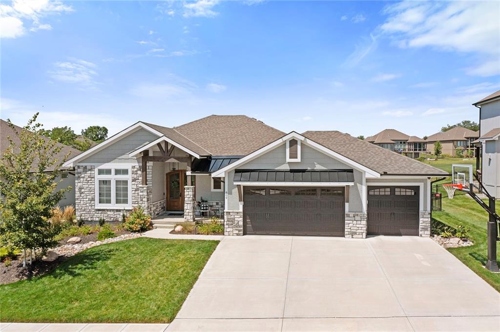 Just 3.5 yrs young and enhanced with over $100,000 in intentional upgrades, this reverse 1.5-story overlooking the golf course is refined without being fussy. Sunlight washes across rich hardwood floors. Custom plantation shutters frame sweeping fairway views. The open design flows with purpose — every space connected, every finish deliberate. The kitchen is built for performance and presence: an oversized island, designer cabinetry, and a walk-in pantry generous enough for serious culinary ambition. It opens seamlessly to the living and dining areas because the best gatherings never happen in isolation. The primary suite is a private retreat, offering a spa-inspired bath with soaking tub, custom shower, and expansive closet space. Nearby, a thoughtfully designed laundry and mudroom with custom cabinetry and drop zone proves luxury should also be practical. The finished lower level raises the standard for entertaining — media lounge, full wet bar, and a dedicated wine tasting room designed for evenings that linger. Outside, the experience continues. A covered deck with fireplace and integrated media overlooks the 16th tee box. The custom outdoor kitchen, complete with Coyote appliances and Komodo smoker, makes game day legendary. Later, unwind in the 7-person Bull Frog spa beneath open skies and rolling greens. Additional features include an 80-amp dedicated EV circuit in the third garage bay (charger ready), plus pre-wiring and gas plumbing for a future pool. This is not merely a golf course home. It is a declaration of how you intend to live.