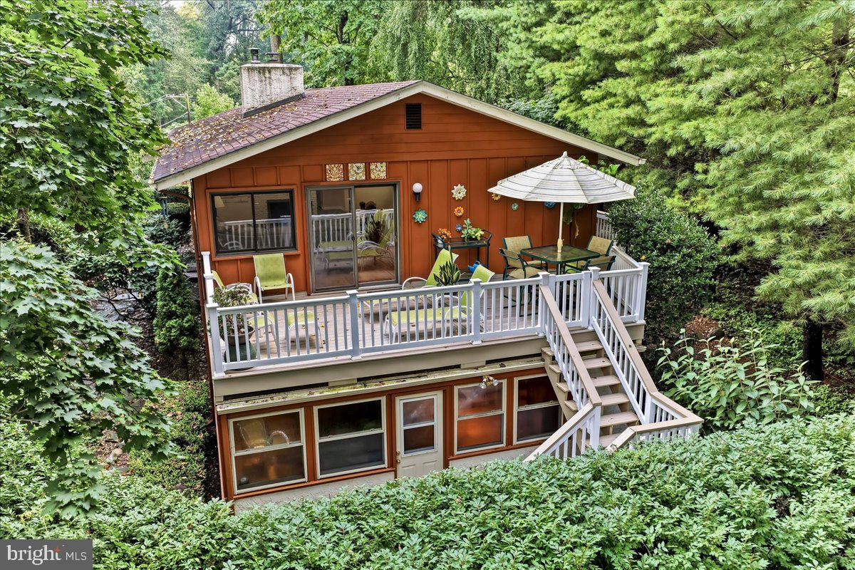 Architectural integrity meets an elevated "life in the canopy" at this striking mid-century modern retreat. Set on nearly an acre of mature greenery, this is a home that refuses to be ordinary, offering a sophisticated bi-level footprint that prioritizes light, texture, and a seamless connection to the outdoors.The experience begins in the slate-floored foyer, leading you upward into a bright, open-concept living space. The kitchen is a study in warmth and function, featuring maple cabinetry, a perfectly positioned sun-drenched skylight, and a peninsula designed for morning coffee and casual conversation. The kitchen refrigerator has a water filtration system. It flows effortlessly into the dining area and a commanding great room, where a wood-burning fireplace anchors the space. Here, hardwood floors and oversized windows frame lush, panoramic views of the surrounding woods. Step through the glass sliders onto the expansive deck to truly understand why this has  been known as "the home in the trees"—an outdoor sanctuary perfect for dining amidst the treetops in total privacy.The upper level hosts three well-appointed bedrooms, including a primary suite defined by dual-exposure light and a private bath featuring a sealed steam shower. The additional bedrooms are equally impressive, with original hardwood flooring and ceiling fans. The hallway bath serves as a design focal point with its glass vessel sink and vibrant vanity, all illuminated by natural light of another skylight.The lower level transitions into a premier destination for recreation and wellness. A built-in wood bar and dedicated 350 bottle wine cellar set the stage for effortless hosting, while the sunroom—currently utilized as a fitness studio—houses a private sauna and opens directly to the lower patio. A flexible fourth bedroom offers the ideal footprint for a secluded home office or guest space.Practicality is woven into the design with an attached two-car garage and a fenced side yard that provides open space within this wooded enclave. Recent upgrades, including a new AC system (2026) and a double-walled Roth oil tank (2023), ensure peace of mind.Perfectly positioned for a lifestyle of convenience, this home is served by the award-winning Tredyffrin-Easttown School District. Enjoy easy access to the Daylesford train station for commutes to the city, and living just moments away from the Upper Main Line YMCA and the premier shopping and dining of the Main Line. This is a residence that lives large, feels intimate, and offers a daily escape from the everyday.  Schedule your showing today!