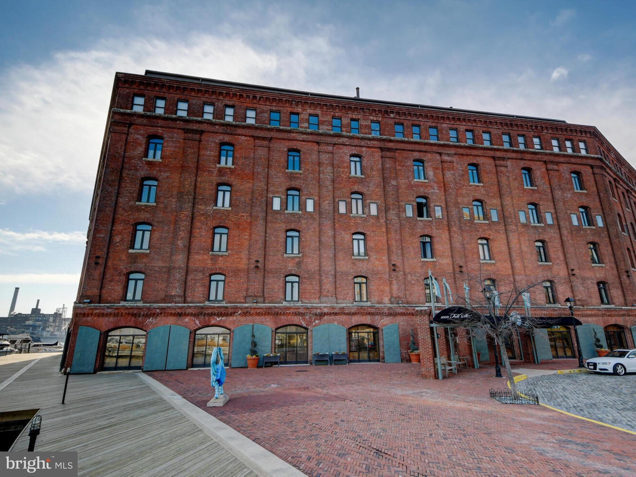 Wonderfully situated condo on the second floor of beautiful Henderson's Wharf facing the quaint cobblestone streets as well as the water. This is a large, two-level unit with same floor deeded parking. The home is so warm and welcoming thanks to the beautiful exposed brick throughout (recently sealed), the warm flooring, and the golden light that shines through large windows on each floor which open and have built in custom window screens. The kitchen has beautiful stone countertops, brand new appliances (dishwasher, stove and microwave), and white cabinets. Upstairs, the bedroom has a custom built "Elfa" closet system, an updated full bath with new shower system, and a new hot water tank. Laundry is on the bedroom level as well. Soaring ceilings and great views and light really set this home apart. Henderson's Wharf is an upscale waterfront building with newly renovated lobby, a beautiful atrium outdoor space, secure parking, an elevator, and a newly renovated fitness facility. It is located in a beautiful quiet corner of iconic Fell's point that is walkable west to Harbor Point and Harbor East, east to Canton, and north to Johns Hopkins Hospital Campus. Situated adjacent to the marinas if you need to bring your boat!