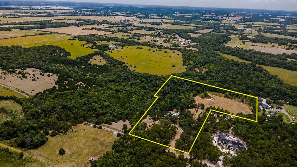 Welcome to Serendipity Acres, a gated 16 acre retreat in Celina offering mature trees, ag exempt acreage, horse and livestock potential, fenced pasture, year round creek, two seasonal ponds, pool and barn. Enter through the electronic gate and follow the tree-canopied drive into this peaceful country setting. The property currently benefits from an agricultural exemption supported by goats and includes a two stall barn with lean to storage, chicken coop and approximately 11 unrestricted acres with potential for an additional estate home or homesite, subject to applicable governmental approvals.A  creek winds through the backyard beneath mature trees, with abundant wildlife, native birds and approximately 20 mature fruit trees adding to the natural setting.The beautifully maintained 3 bedroom, 2 bath home features expansive porches and decking with ceiling fans. Inside, the family room offers a river rock fireplace with custom walnut mantel. The primary suite features a claw foot tub, while the adjoining sunroom showcases shiplap and pine ceilings with views of the acreage.Outdoor living includes a swimming pool with tanning ledge, installed in 2020, plus an Austin stone fire pit. The separate man cave and party barn offers space for entertaining, recreation or hobbies and includes two A C units and a pot-belly stove. Additional improvements include a two car garage with tool storage and RV boat parking with electrical hookup.The 5 acre portion is fenced, while the adjoining 11 unrestricted acres are fenced on three sides. Serendipity Acres combines gated Celina acreage, ag exempt land, horse property, mature trees, creek, ponds, pool, barn, chicken coop, party barn and unrestricted acreage with additional homesite possibilities. No HOA, MUD or PID taxes. Ideal for a private country estate, multigenerational retreat, horses or livestock in Celina, Collin County and Celina ISD.Sellers are both active licensed Real Estate Agents in Texas.
