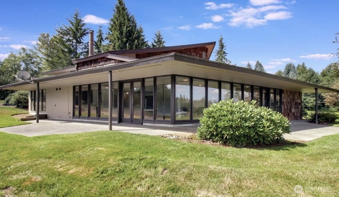Experience timeless design and serene privacy on 27.8 acres with this Frank Lloyd Wright-inspired estate. With 5 bedrooms, 4 bathrooms, and 3,200 sqft, this architectural gem boasts a soaring beam ceiling, a wall of windows, and breathtaking panoramic views. Enjoy a separate entry upper-level MIL apartment, efficient geothermal heating, an attached 3-car garage, as well as a 3-bay shop and an RV pad with utility hookups. R5 zoning offers significant value with potential for future subdivision. Buyer to verify. Enjoy abundant wildlife, water features, and the nearby Centennial Trail. Minutes from town yet a world away— A rare blend of privacy, design, and opportunity—your exceptional Pacific Northwest legacy property awaits.