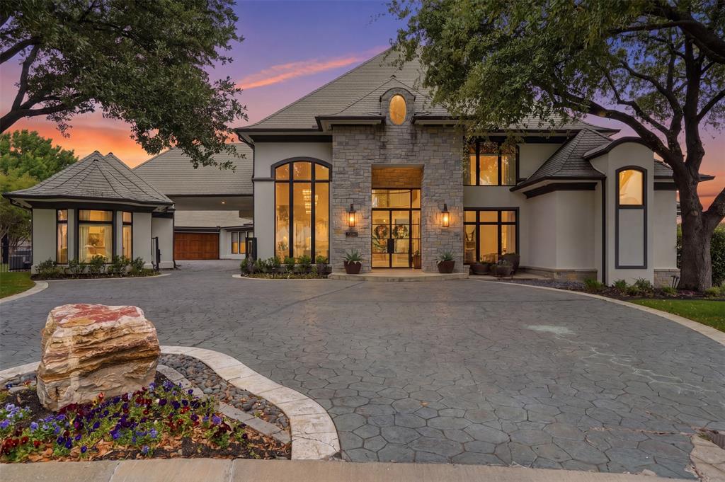 Refined, architectural elegance meets effortless luxury in this stunning estate, perfectly positioned on the 7th hole of Mira Vista Country Club with lake views. Every detail has been thoughtfully curated for both grand entertaining and everyday living. Set at the end of a cul-de-sac and framed by mature trees, the striking stone-and-stucco façade makes an unforgettable first impression.Inside, soaring ceilings and expansive walls of glass flood the home with natural light, seamlessly connecting indoor and outdoor living. The main living area showcases a dramatic fireplace, wide-plank hardwood floors, and panoramic views of the resort-style backyard and golf course. A designer kitchen anchors the home with an oversized marble island, professional-grade appliances, custom cabinetry, and an open flow into multiple gathering spaces.The primary suite is a true retreat, featuring a striking see-through fireplace shared with the spa-inspired bathroom, creating a serene, resort-like ambiance. The bath is wrapped in luxurious marble and includes a freestanding soaking tub and dual walk-in showers. All six generously sized bedrooms feature private en suite baths, offering comfort and privacy for family and guests alike. Additional living spaces include a sophisticated dining room with statement lighting and custom wall treatments and a private office with custom built-ins offer many flexible areas for work or leisure.Separate guest quarters offer exceptional flexibility, complete with a full kitchen and full bathroom—ideal for extended stays, guests, or private flex space.Step outside to your private oasis—an expansive patio, sparkling pool, gas fire pit, and manicured grounds overlooking serene green space create the ultimate setting for relaxation or entertaining under the stars.With its seamless blend of modern sophistication and timeless design, this exceptional property offers elevated living at every turn.
