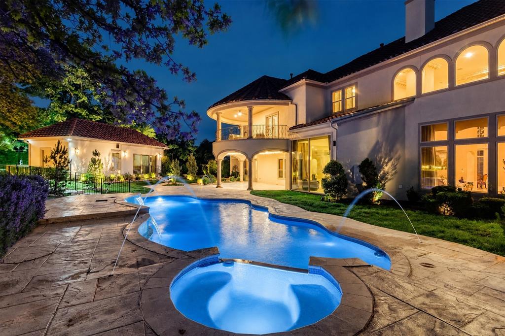 A stunning Mediterranean estate designed for those who love to entertain and live exceptionally well, this 7,499 square foot residence sits on 1.82 acres in a cul-de-sac on the golf course within the prestigious Estates at Tour 18, a 24-7 guarded and gated community. From the moment you step inside, soaring 25-foot ceilings create a dramatic and inviting presence, setting the tone for a home that is both grand and welcoming. Designed for hosting on any scale, the home features a dedicated media room, an large game room with kitchenette, and seamless indoor-outdoor living. The resort-style backyard offers a sports court, pool, and an impressive gas firepit, making it the perfect setting for unforgettable gatherings. At the heart of the home, the oversized kitchen is as functional as it is beautiful, featuring dual dishwashers, a vegetable sink, and striking lighted Cristallo countertops. Around the corner, a built-in desk area provides space for homework or everyday organization. The secluded master suite is a true retreat, complete with a sitting area. A versatile bonus room with a closet, ideal for a nursery, private office, craft room, or additional storage is nearby. The spa-like master bath offers a steam shower, rain head, and a towel warmer for a true luxury experience. Three additional bedrooms are upstairs, including one with its own balcony. A separate guest house offers comfort for extended stays or multigenerational living. Every detail has been carefully chosen, from marble countertops in all bathrooms to a central vac system, electronic window treatments, and chandeliers that lower electronically for easy maintenance. Set within one of the area’s most sought-after gated communities with scenic golf course views, this home offers a rare combination of privacy, scale, and elevated living. You can keep searching… but you won’t find another one like this. Many furnishings in the home are available for purchase. Seller holds a TX real estate broker license.