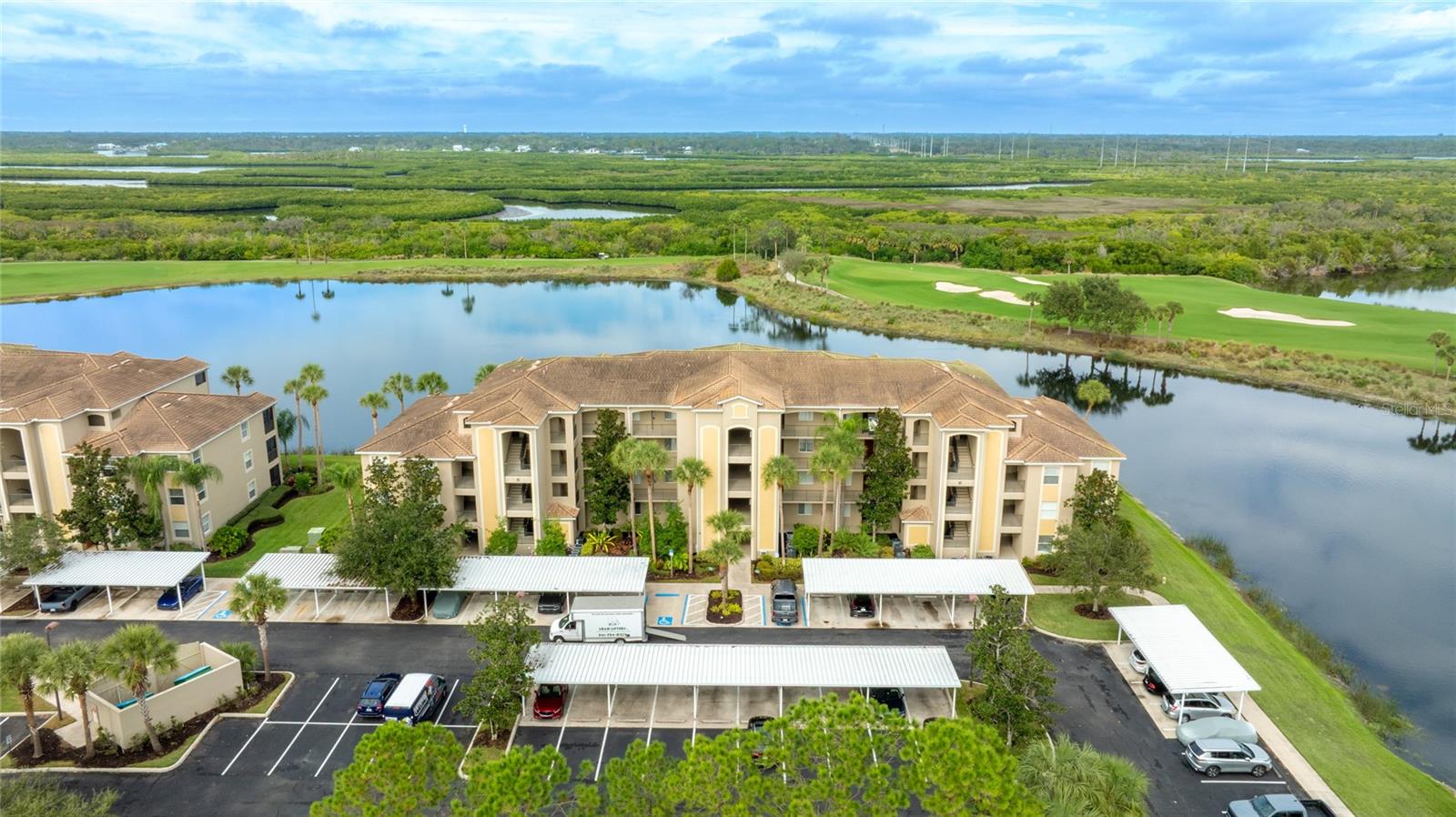 Your Premier River Strand Golf & Country Club Lifestyle Awaits! Welcome to this absolutely stunning, move-in-ready, TURNKEY (all furnishings included!) ground-floor condo, perfectly positioned to offer gorgeous, unobstructed water views that you can enjoy every day. This open-concept sanctuary is flooded with natural light thanks to a magnificent wall of windows, immediately welcoming you to the best of Florida living.Inside, you'll find elegant tile flooring throughout the main living areas and a beautifully appointed kitchen featuring stainless steel appliances. The spacious owner’s retreat is a private haven, complete with an en suite bathroom and dual, generously sized walk-in closets. An additional well-sized guest bedroom ensures comfort for visitors. Step out onto your screened-in, covered lanai—it's the ideal, peaceful spot for relaxing or entertaining while taking in the scenic natural surroundings.The value proposition here is truly exceptional: this unit includes a deeded, full golf membership! You gain immediate access to the River Strand Golf & Country Club, home to the challenging 27-hole Arthur Hills–designed championship golf course. River Strand is renowned for its vibrant, active community atmosphere and abundant outdoor and lifestyle amenitiesExceptional Community Amenities: The Clubhouse: A spectacular 39,000-sq-ft facility featuring a semi-formal dining area, Grille room, and a fully stocked on-site bar and restaurant.Golf & Racquet Sports: Beyond the course, enjoy a Golf Pro Shop with the latest technology, certified teaching professionals, a Racquet Sports Pro Shop, 9 Har-Tru clay tennis courts, and newly installed pickleball courts. Racquet services, including lessons and re-stringing, are available!Pools & Fitness: Choose from two resort-style pools (one at the Clubhouse and one at the Community Center), two heated spas, a resistance pool, and six satellite pools throughout the community. Stay active with two fully equipped fitness centers, an aerobics room, and half-court basketball courts.Social Life: The community thrives with frequent social gatherings and events, including live entertainment throughout the year, holiday parties, trivia nights, Name That Tune competitions, pool parties, plus activities like Bridge, Mah Jong, and Bingo. Don't forget the popular Tiki Bar!This property represents an exceptional value for River Strand living. Everything you could ever want for a luxury, active, and social lifestyle is right here waiting for you!