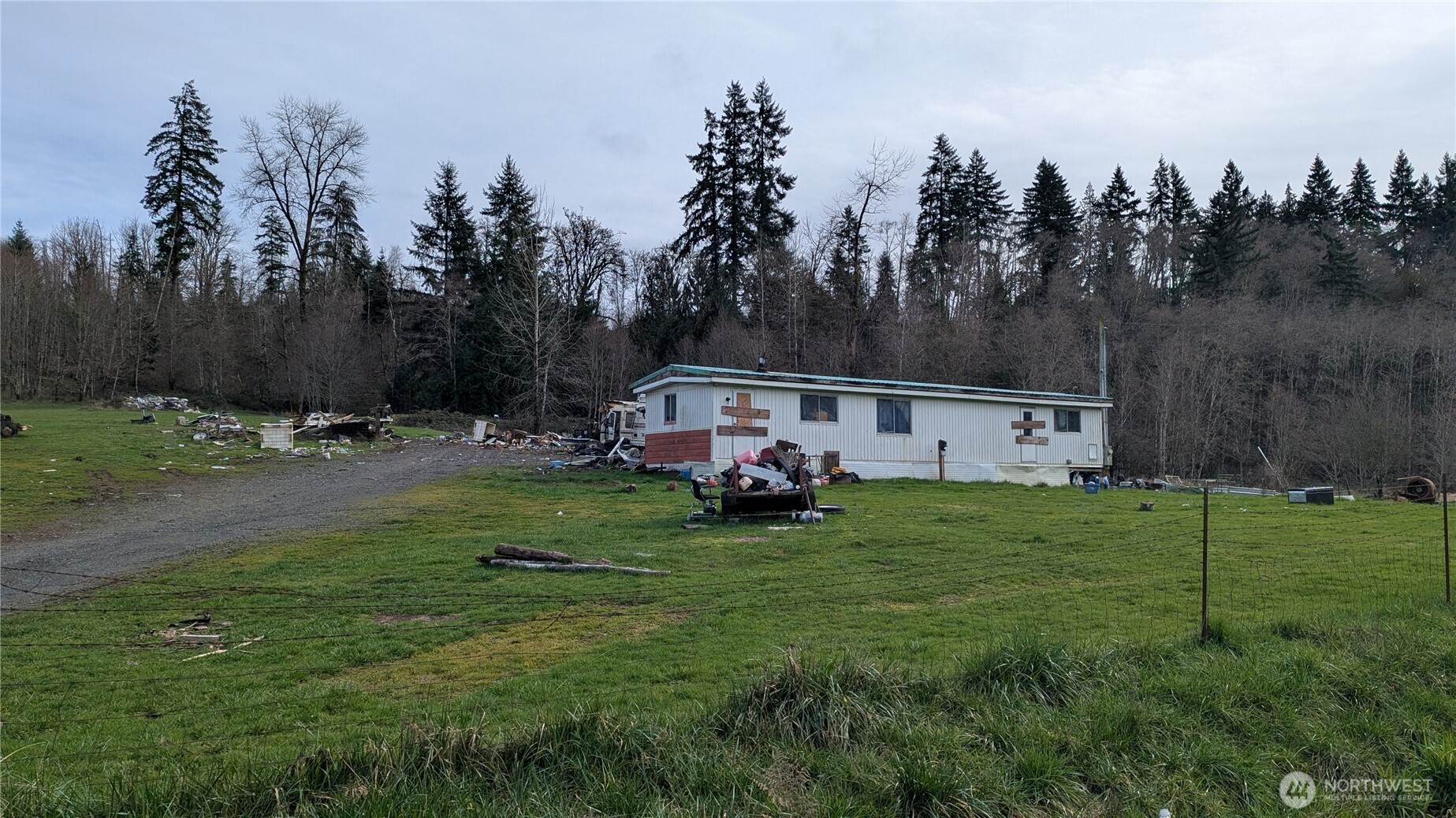 Just under five aces located on quiet country rd just outside of town.Property is level to sloping with tons of potential. Property is in the process of being cleaned up. The majority of the cars will be removed along with the majority of scrap/junk.  Property has an old single wide on it that is of no value. This is an estate and the seller has limited knowledge of the water source, septic, etc. Please do not enter home without prior approval.