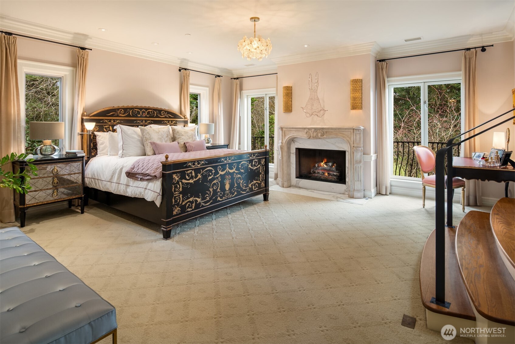 Elegant primary bedroom with cozy fireplace and sitting area.