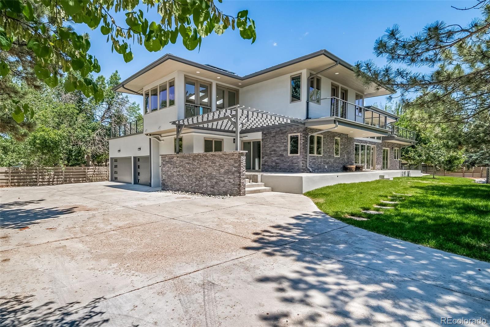 Stunning new custom modern home showcasing luxury finishes, thoughtful design, and energy-efficient living. Nestled in the desirable Cobblestone Court neighborhood, this light-filled retreat offers 3,069 square feet of above-grade living space on an expansive 0.3-acre lot. Designed for both everyday living and entertaining, the open-concept floor plan seamlessly connects the living room, dining area, and chef's kitchen, all enhanced by abundant natural light and premium designer finishes. Highlights include high-end Italian Bertazzoni appliances, radiant heated floors, Andersen windows, a durable metal roof, quartzite countertops and waterfall island, four balconies and decks, a fully owned 6kW solar system, pergola, and professionally landscaped front and back yards with full fencing. The oversized 3-car garage is EV-ready and complemented by an expansive driveway with parking for up to 10 additional vehicles. A welcoming foyer opens into the main living spaces, formal dining area, and gourmet kitchen. The main level also features a spacious bedroom that can serve as a primary suite, along with a private study, gym, or yoga room showcasing picture-window views of the Flatirons. Upstairs, the luxurious primary suite offers a spa-inspired five-piece bath and a private walkout deck with sweeping mountain and golf course views. The second level also includes a versatile loft, a skylit media/recreation room with rooftop deck access, a full bath, and two additional bedrooms, each with direct access to its own private outdoor space.