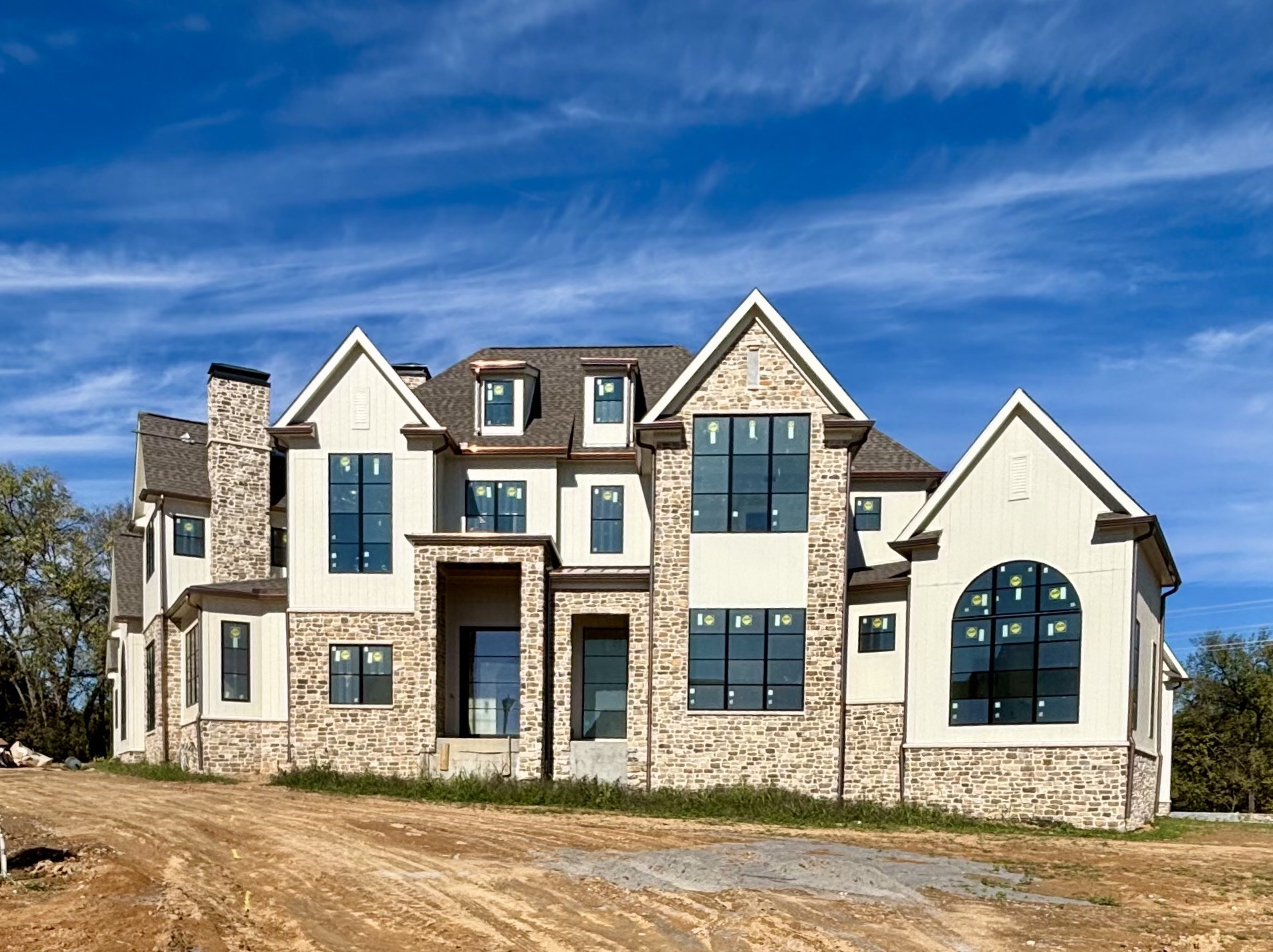 This custom luxury home by award-winning Arnold Homes is a masterpiece of elegance and functionality. A covered porch with an iron swing door welcomes you into an expanded foyer, which flows seamlessly into the open living and dining areas. Three sets of double doors provide breathtaking views of the rear covered porch, pool, and putting green. Designed for the ultimate culinary experience, the chef’s kitchen is complemented by a spacious Martha Stewart-inspired scullery. The opulent primary suite features a walk-around bar, a private office, and a dedicated massage room with a sauna. A breakfast terrace connects to a combined laundry and office space, offering added convenience. Perfect for entertaining, the covered porch is outfitted with a hibachi grill, pizza oven, and built-in grill with a vented hood. The main-level media and billiards room, which has access to a full bath, can also serve as a pool bath. Additionally, a connected poker room offers a private covered porch. Skylights flood the rear hallway with natural light, enhancing the ambiance of the space. The spa-like primary bath boasts a walk-through shower, separate his-and-hers vanities, private water closets, custom walk-in closets, and access to a stackable laundry. Upstairs, four additional bedrooms each feature en-suite baths, along with a separate walk-in laundry area for convenience. A dedicated podcast room near the bonus room includes built-in bunk beds and access to a large storage space. Car enthusiasts will appreciate the five-car garage with high ceilings, allowing for car lifts. Nestled on a private cul-de-sac street, this estate is surrounded by lush trees and features a luxurious pool, spa, and putting green—offering a resort-like experience at home.