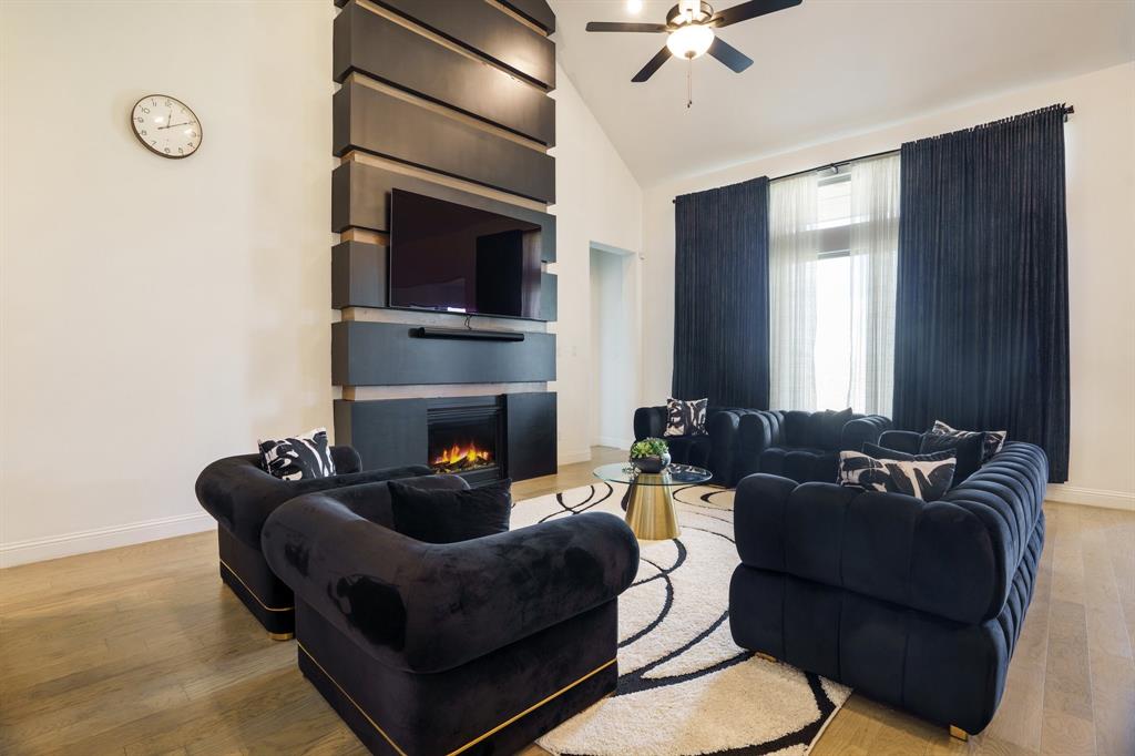 Sleek, soulful, and undeniably stylish—205 Calmwater Cove redefines suburban living in the amenity-rich enclave of Trinity Falls. From the moment you walk in, every detail feels intentional.

A private study with a custom wood accent wall greets you off the entry, leading to a dramatic reimagining of the formal dining space—now a built-in bar designed for elevated entertaining. The open-concept living area is anchored by a soaring floor-to-ceiling custom fireplace, wrapped in natural light and bold design. The adjacent kitchen offers expansive cabinetry, quartz counters, and seamless flow—perfect for hosting or everyday living.

The primary suite delivers drama with a statement wood accent wall and custom LED lighting that sets the tone for luxury. The ensuite bath evokes a sophisticated spa, complete with dual vanities, a soaking tub, oversized shower, and a walk-in closet that exceeds expectations. A secondary bedroom downstairs with its own en-suite bath provides the ideal setup for guests or multigenerational living.

Upstairs, versatility reigns with a dedicated media room, game room, second office nook, and two additional bedrooms—one with a private en-suite and another served by a full bath.

The home also features a spacious 3-car garage, offering ample room for vehicles, storage, or hobbies.

Out back, a nicely sized yard and expansive covered patio with built-in gas stub create the perfect setting for grilling, gathering, or simply enjoying a quiet evening.

Set within McKinney’s premier master-planned community, Trinity Falls offers resort-style pools, wooded trails, lakeside parks, dog parks, a fitness lodge, and an on-site elementary—just minutes from Hwy 75 and the 380 corridor.

205 Calmwater Cove is more than a home—it’s a curated experience in design-forward living.