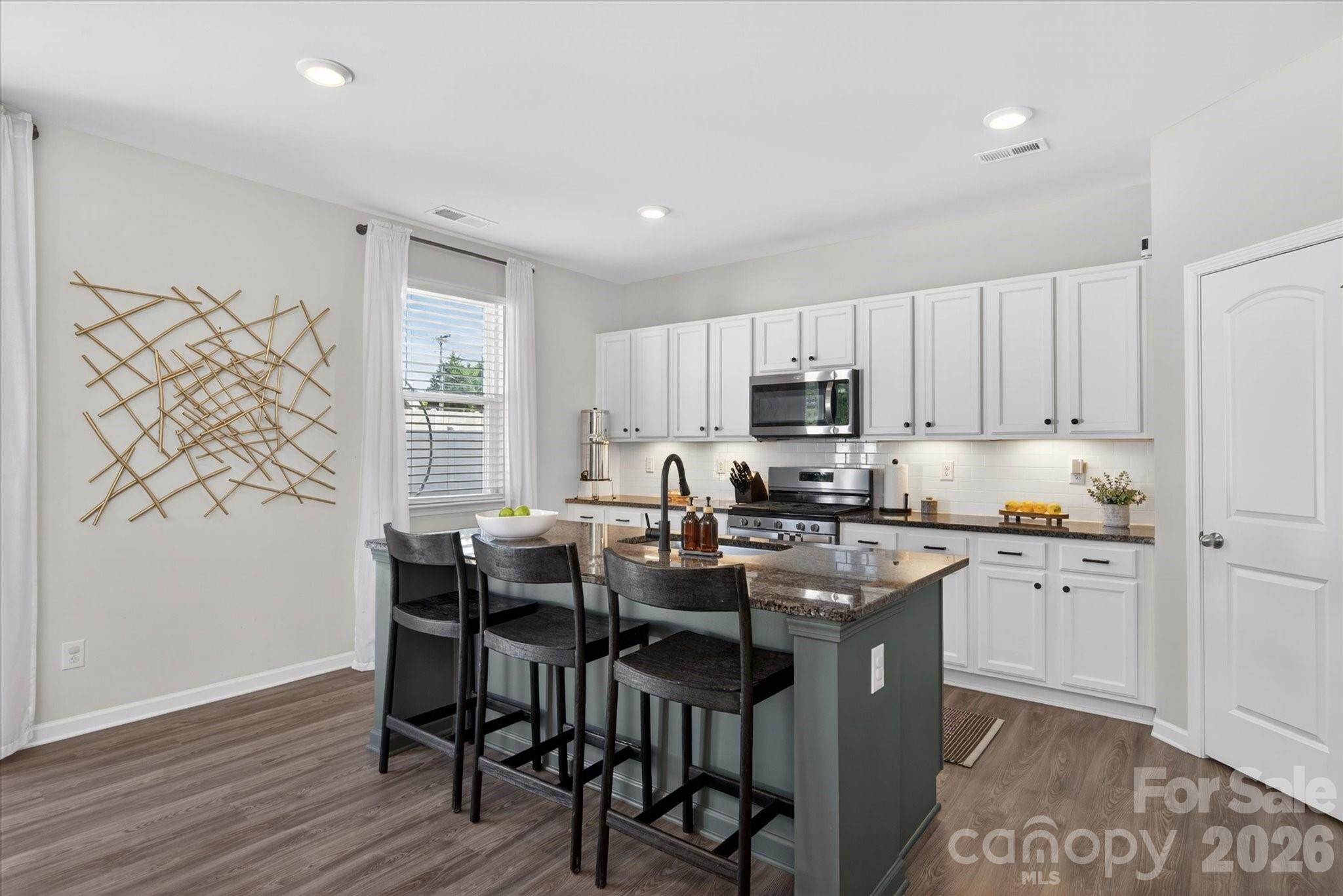 Step into a home that feels like a breath of fresh air - where cozy meets tranquil in a beautiful blend of warm earth tones, natural wood accents, and a calming, zen-inspired design.  Plenty of sunlight throughout the open floor plan highlights the bright white kitchen complete with a spacious island perfect for gathering, entertaining, or enjoying everyday living. Thoughtfully designed accent wall with shiplap, modern fireplace, and natural wood mantel create a warm and comfortable living space.  A dedicated main floor office offers the ideal space for productivity or a quiet retreat.  Upstairs you'll find three generously sized bedrooms with WALK-IN closets, two full baths, and a large recreational room perfect for a media room, playroom, gym, or additional gathering place. Enjoy the fully fenced backyard with a patio, plus a play set and trampoline ready for summer fun! Walk to the community pool and playground and enjoy time with neighbors and friends. Perfectly located just minutes from Wesley Chapel Town Center, Target, and a brand-new Publix opening soon! Nearly new and build in 2021-original owners-meticulously maintained-FRESHLY painted! Welcome to your new home!