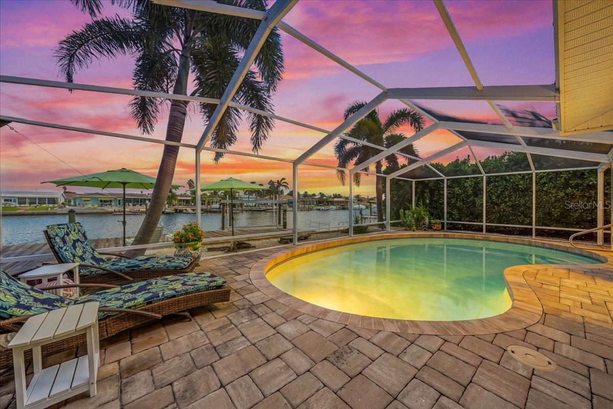 Virtually Staged. DEEP-WATER GULF ACCESS, 80 FT of WATERFRONT, A PRIVATE SCREENED POOL, AND A KITCHEN MADE FOR ENTERTAINING—welcome to your Florida waterfront wish list at 5448 Pilots Place! Located in the established boating community of Gulf Harbors, this upgraded 3-bedroom, 3-bathroom home pairs direct Gulf access with the comforts that make paradise feel like home.Keep your boat in your own backyard on the 10,000-pound lift with dedicated power, enjoy the recently redecked floating dock, and trade trailering and crowded boat ramps for spontaneous days on the water from your backyard. From island hopping and fishing to sunset cruises, your next adventure starts at your dock.Back home, the spacious screened in pool with nebula lighting invites you to keep the vacation going. A sparkling pool with LED lighting, an expansive paved patio, and privacy on both sides create an inviting setting for afternoon swims, dinner with friends, and relaxed evenings overlooking the canal.The gourmet kitchen delivers with an impressive 48-inch, eight-burner gas range, double convection ovens, a drawer microwave, matching four door refrigerator and dishwasher, and a dedicated wine bar. Whether you’re preparing the day’s catch or hosting your first Florida holiday, this kitchen is ready for the occasion. Plank tile flooring in the living area, and plantation shutters (living area, and primary suite) bring a polished coastal feel to the interior.The spacious primary suite features an oversized walk-in closet and an ensuite bath with dual vanities, a heated towel rack, fog-resistant lit mirrors, and a beautifully remodeled shower. Additional bedrooms offer custom built-out closets, while the third bedroom includes its own ensuite bathroom and walk-in closet—an inviting setup for visiting guests.Practical upgrades complement the waterfront lifestyle: impact-rated windows and doors throughout, a 2024 A/C system, a new water heater, a water softener, and indoor laundry. The garage adds epoxy flooring and an EV charging plug.Make your move to the Gulf Coast with the boat lift, pool, entertaining spaces, and thoughtful upgrades already in place. Gulf Harbors features OPTIONAL HOA of ONLY $125 a year which includes fabulous events all year long such as concerts, boat parades and more! The entire neighborhood is also golf cart friendly with easy access via Marine to downtown New Port Richey. The community has a sacred private beach available for Members only, which is gated, with 21 cabanas and includes grills and bathrooms, and showers for only $200 a year! Schedule your private showing and discover what everyday life could look like in Gulf Harbors. You will absolutely LOVE IT HERE!!