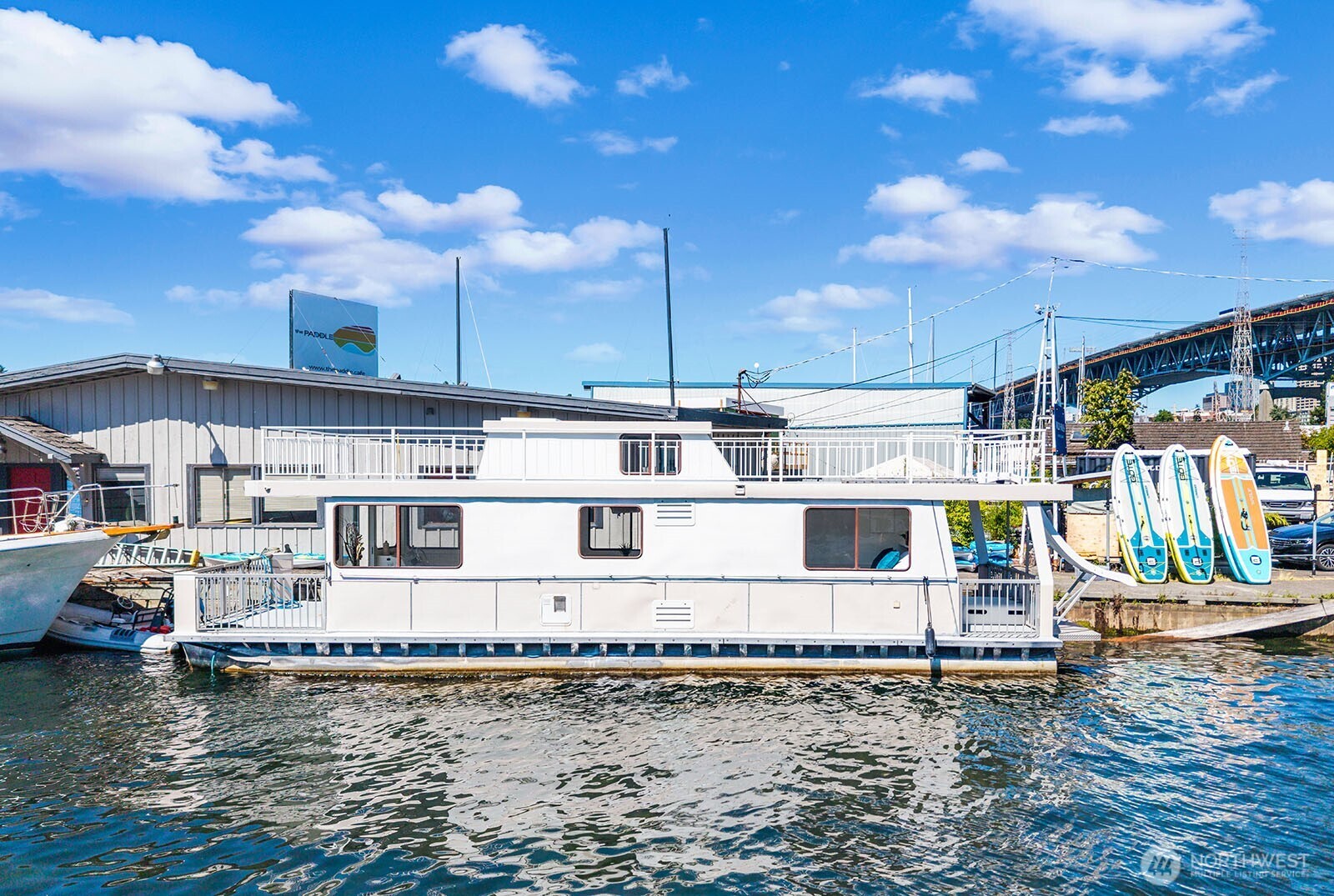 Nestled in the sought-after Eastlake community, this charming houseboat is the perfect blend of comfort and lifestyle. Updated and designed with a functional layout, “Little Happiness” features a cozy living room, inviting kitchen with dining area, one bedroom, a spacious sleeping loft, and a ¾ bath. The hull measures approximately 45’ x 15’, and is built on steel pontoons, providing a comfortable and efficient living space to enjoy life on Lake Union.  The showstopping rooftop deck is your private escape with panoramic views and unforgettable Seattle sunsets. Imagine starting your morning with coffee living on the lake! Spend mornings, afternoons and weekends with nearby amenities; pop over to FRAM to sip and enjoy the surroundings, enjoy paddle boarding, relax at Wild Haus Sauna, explore the parks, pea patch and all the vibrant neighborhood amenities that make Eastlake so desirable.  A rare opportunity to embrace a more inspired way of living — “Little Happiness” is a hip, unique alternative to traditional condo living. Whether you’re seeking a full-time residence, a weekend retreat, or a one-of-a-kind Seattle experience, this beautifully updated houseboat offers houseboat living with personality, charm, and endless possibilities. See to believe!