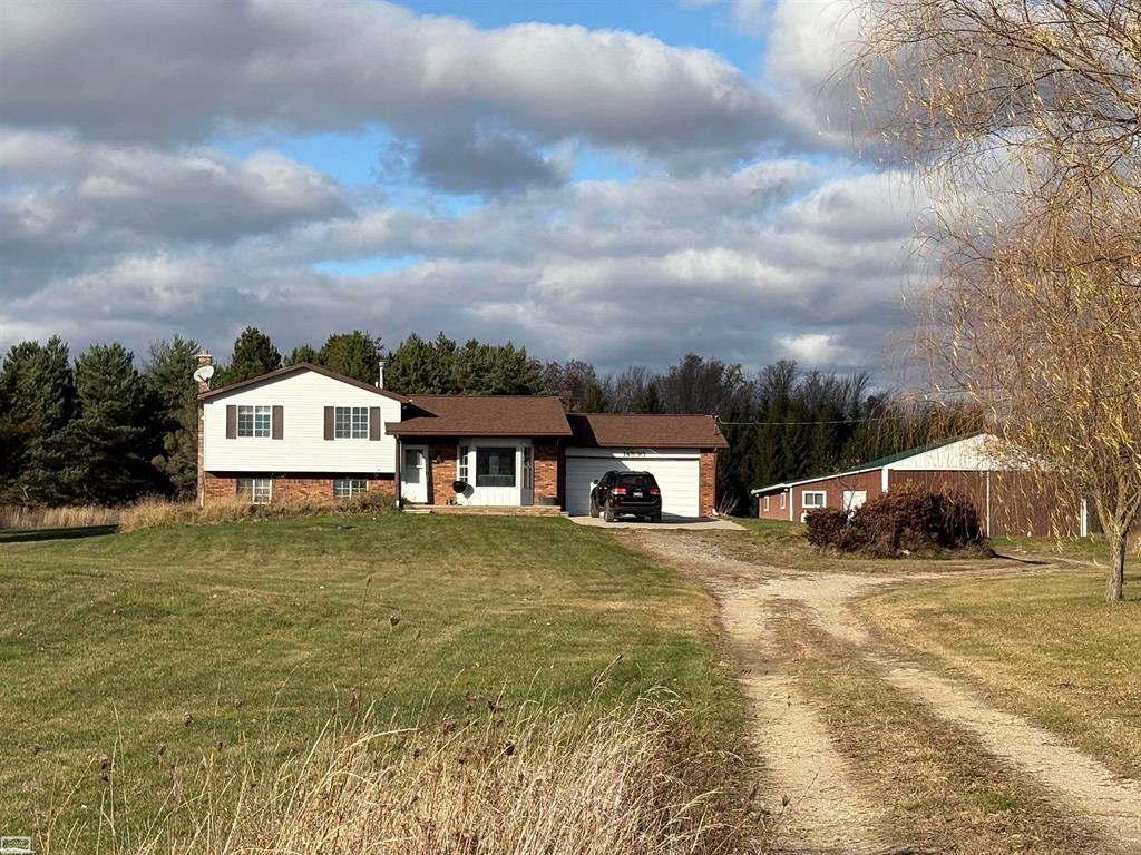 Quad-level country estate perched high on a scenic knoll, overlooking 40 beautifully manicured acres accented by mature pines and two tranquil ponds. This inviting property offers exceptional versatility with a pole barn, attached workshop, greenhouse, and chicken coop-ideal for those seeking space, privacy, and room to create their vision.  The setting is peaceful and private, surrounded by abundant wildlife including deer and turkey. A short walk through the tall pines leads to a charming bonus country cabin tucked at the rear of the property, overlooking the second pond-an unexpected retreat that adds character and charm.  The home presents a wonderful opportunity for a new owner to make personal updates and improvements while enjoying the rare combination of land, outbuildings and natural beauty. 10K window & flooring allowance/concessions.