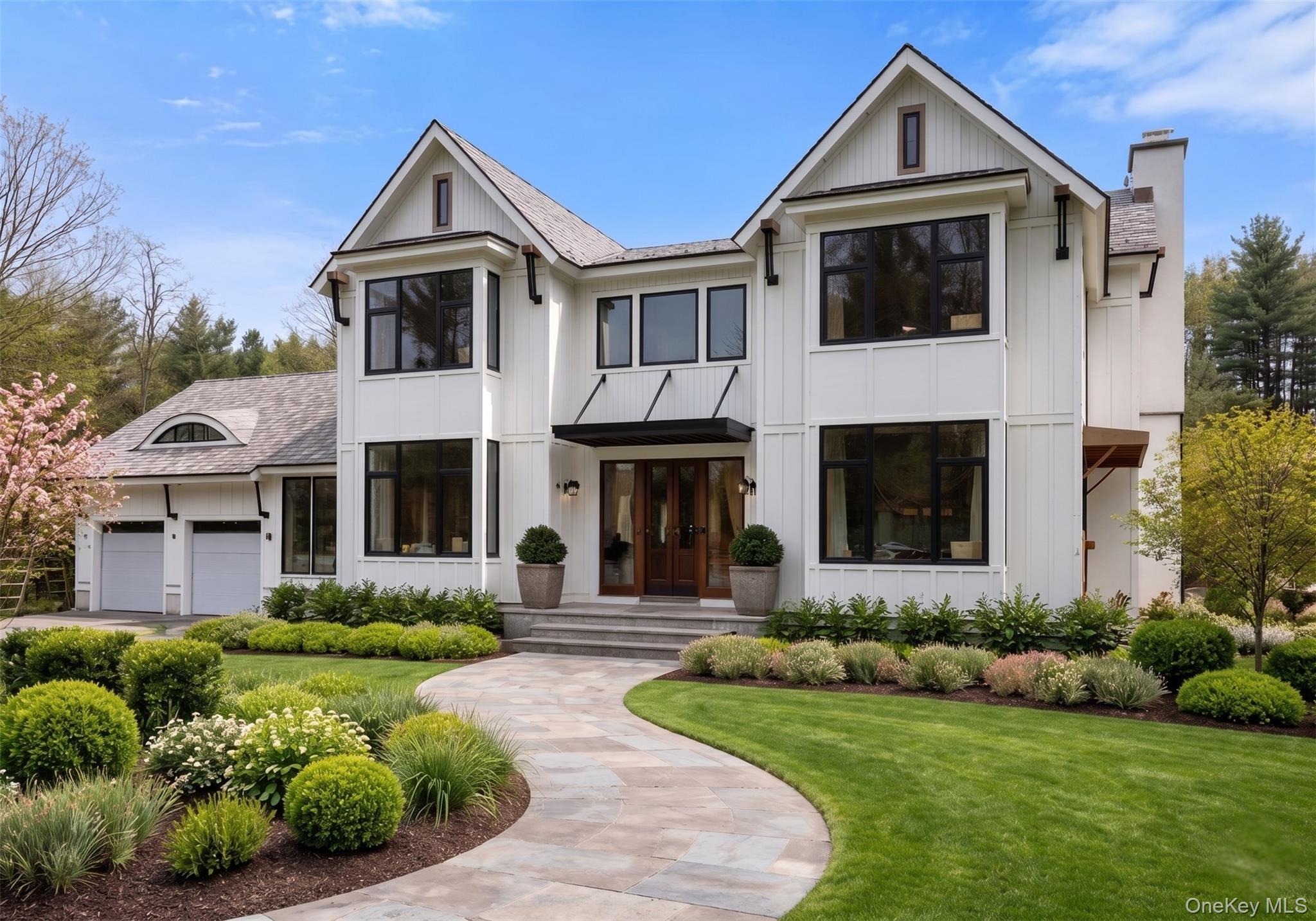 New construction in the heart of Pound Ridge, this modern European-inspired residence is gracefully set on a picturesque property overlooking Pinebrook Road. Thoughtfully designed to blend clean architectural lines with warm, natural materials, the home is complemented by a charming, fully renovated two-bedroom, 861-square-foot cottage—ideal for guests, extended stays, or flexible living. Offering five bedrooms and five-and-a-half baths, the residence is designed with both scale and sophistication in mind. Ten-foot ceilings define the main level, while a dramatic 12-foot great room and vaulted second-floor ceilings create an airy, light-filled atmosphere throughout. Wide-plank, pre-finished walnut floors, custom millwork, and a curated mix of shiplap and reclaimed beams lend richness and character at every turn.The custom kitchen will feature refined white cabinetry, quartz countertops, and an expansive center island, complemented by a full appliance package—seamlessly blending function and style. The primary suite offers a tranquil retreat with a spa-like ensuite bath and walk-in closet. Each additional bathroom is appointed with heated floors, custom vanities, and marble finishes. An unfinished, above-grade lower level with nine-foot ceilings and rough plumbing provides approximately 1,500 square feet of opportunity for future living space. A separate 800-square-foot bonus area offers further flexibility for recreation, office, or guest accommodations.Exterior details are equally compelling, with Hardie siding and trim, a striking engineered slate roof, and oversized European windows designed to maximize natural light. Bluestone patios, professional landscaping, irrigation, and a heated gunite pool with surrounding stonework create a private outdoor retreat. A semi-circular pergola with open beams (no roof) serves as a distinctive architectural focal point, perfectly positioned to frame and enjoy the exterior side of the double-sided fireplace—an inviting setting for both intimate evenings and effortless entertaining. Located just minutes from top-rated schools, everyday shopping, and beautiful recreational spots like Bedford Village Memorial Park and the expansive Ward Pound Ridge Reservation.