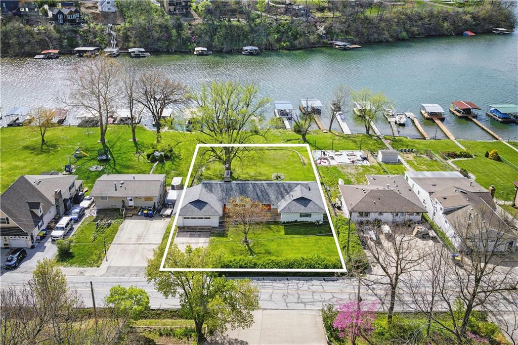 Dreaming of life at the lake but can't find the right house? HERE IS THE RARE OPPORTUNITY! Located on a double lakefront lot nestled on a no-wake cove overlooking beautiful Sunrise Bay--not a through street and complete with private dock! The perfect setting to relax, unwind and soak in panoramic views. This sprawling ranch offers endless potential—already equipped with a newer roof and copper plumbing, it’s been taken down to the studs and is ready for you to bring your vision to life. Plans and a contractor estimate are already attached to MLS, making your lakefront dream home closer than ever! At Lake Lotawana—the largest private lake in the Kansas City area—every day feels like vacation. Enjoy sailing regattas, speed boating, ice boating, pontoon cruising, kayaking, canoeing, water skiing, tubing, swimming, fishing tournaments and vibrant community events. Whether you crave peace and quiet or action on the water, this community has it all! Don’t miss your chance to create the ultimate lake lifestyle. WELCOME HOME! Please note: bedroom and bathroom count reflects previous finished layout.