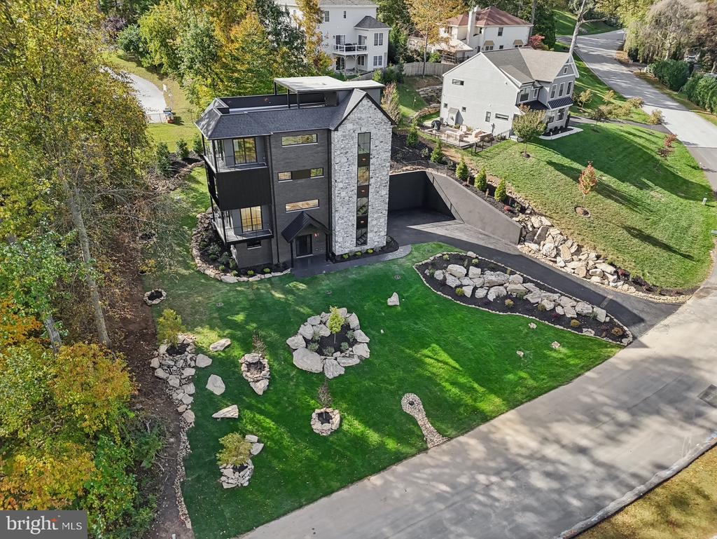 Introducing 12 Langton Lane- a fully custom, 4 bed, 3.5 bath new construction home designed and built by Giappo Design+Build. Known for their sharp eye on blending aesthetics with smart functionality, this magnificent property is tucked away on a quiet cul-de-sac street in the sought after Runnymeade Farms community in Edgmont/Newtown Square. This distinctive 4 story single family home offers gorgeous tree top views from multiple wrap-around corner balconies and what could very well be the only true rooftop deck in the immediate area! Nothing was overlooked throughout the building process and the attention to detail shows in every material that was selected. Enter the home through the black iron double doors where you are greeted by a sleek temperature controlled wine room with wet bar and tasting area. The recreation space to the left is perfect for a home gym or private office- the enormous closet lends to added storage or could be used for an indoor sauna. Easy access to the utility room and a 2-car garage can be found on this level. Ascend up the floating staircase to an unbelievable living area with wide plank engineered white oak floors laid in a mesmerizing herringbone pattern. Experience refined luxury in the breathtaking European-style kitchen designed by Giappo and supplied by Omega Kitchens & Decor. Featuring custom wood grain cabinetry, soft-closing hardware, and glass-front display cabinets with integrated lighting. The expansive 7x9ft single slab Trevi quartz island serves as the focal point, enhanced by LED toe-kick and under-cabinet lighting while the premium finishes include matte black fixtures, professional stainless-steel Thermador appliances, and a clean, open layout that seamlessly blends functionality and beauty. The attached walk-in pantry provides matching cabinets and quartz countertop with bookmarked backsplash offering plenty of additional storage perfect for all your entertaining needs. Off of this level, there is a corner wrap-around balcony and a 10ft double slider to the rear yard lending to more indoor/outdoor living. This space is completed with a powder room and coat closet. Follow to the next floor with an oversized laundry room; an ensuite bedroom with its own private bathroom with curbless shower; a second spacious bedroom that shares a hall bathroom with double sink vanity and tub/shower combo, and a bonus space that could be used as a children’s playroom or office. The primary suite encompasses the majority of the 4th level. Here you will find a stunning black soap stone wet bar with beverage fridge; an office/bonus space with 2 closets (could technically be another bedroom); the primary bedroom with a private wrap around corner balcony and a luxurious primary bathroom with a spa-like shower and a double sink vanity that connects to a massive walk-in closet. The final set of stairs does not disappoint and takes you to the rooftop deck that overlooks the tranquil woods and the covered porch is perfect to place a TV or fireplace. This space is an entertainer's dream! The exterior offers tons of lighting, professional landscaping, and a tiered, rear yard oasis. Located in the highly sought after Rose Tree Media School District, this home is close to the shopping and dining of downtown Media and Ellis Preserve while being close to all major roadways for an easy commute. Call today for more information or to schedule an appointment; this one-of-a-kind property is not to be missed!