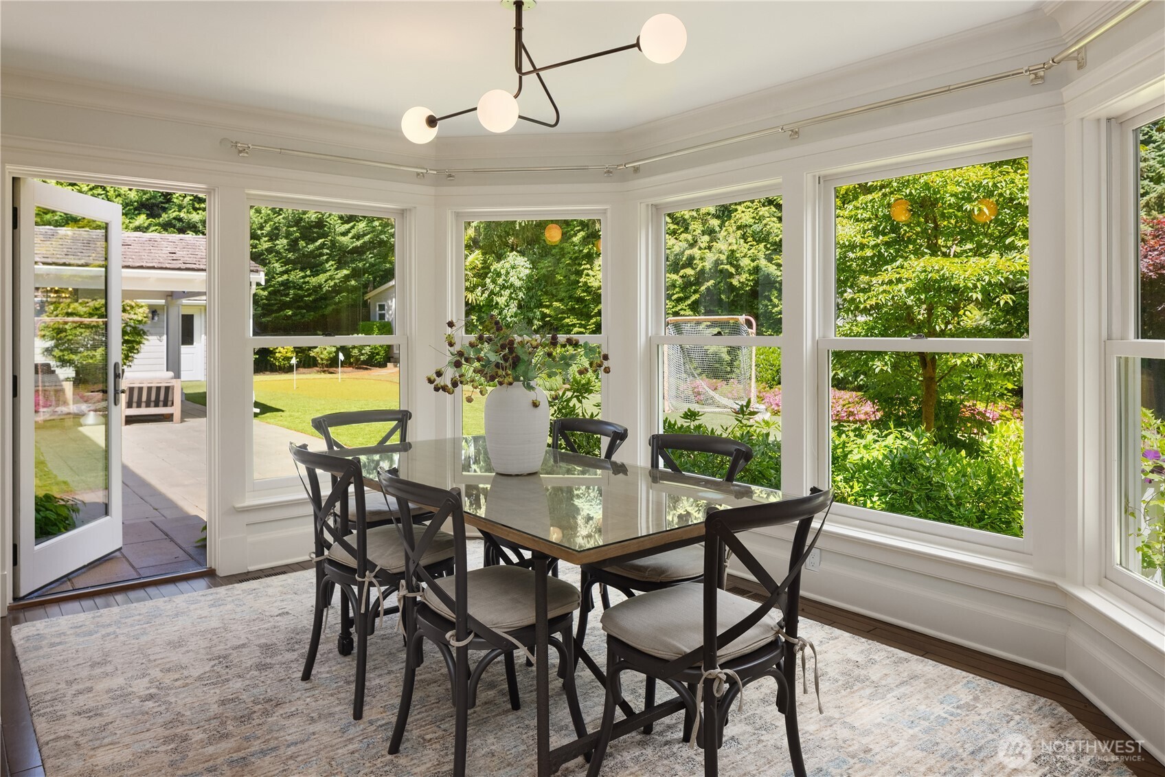 Sun-drenched breakfast nook wrapped in windows overlooking the yard
