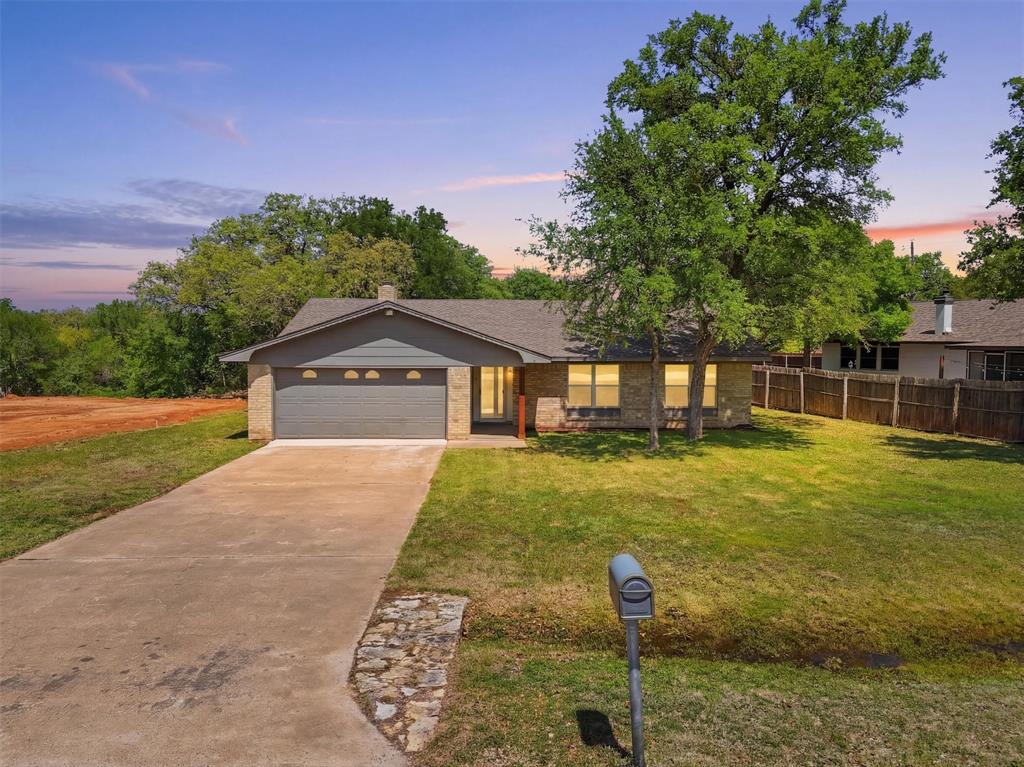 Welcome to DeCordova Bend Estates, where gated golf course living meets everyday comfort. This 3 bedroom, 2 bathroom home offers 1,698 sq ft with a layout that feels open, bright, and easy to live in.Step inside to a spacious living area featuring vaulted ceilings with exposed beams, LVP flooring throughout, and a wood burning fireplace that anchors the space with warmth and character. Natural light fills the room, creating an inviting atmosphere that flows seamlessly into the dining area and kitchen.The kitchen is fresh and functional with painted cabinetry, updated countertops, stainless steel appliances, and a window over the sink that brings in great natural light. Just off the main living space, the bedrooms are well sized with a comfortable primary suite and a practical layout for everyday living.Outside, you will find a large yard with mature trees, a 2 car garage, and plenty of space to enjoy outdoor living.Located inside DeCordova Bend Estates, this home comes with access to a long list of amenities including golf courses, a marina, clubhouse, pickleball courts, volleyball courts, basketball courts, and gated security. Whether you are looking for full time living or a weekend retreat near the lake, this home offers both lifestyle and value in one of Granbury’s most sought after communities.