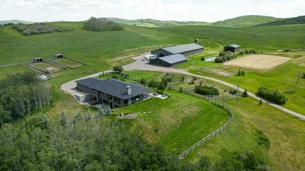 Are you a most discerning buyer? Do you have an eye for true quality? Looking for that Premier Property? This Estate Home and world class Equestrian Facility is all of that and more! Custom 4600 square foot  Builder designed home with nothing but the finest construction and finishing's throughout including an oversized 3 car attached garage. No small matter that you have a 180 degree downtown City of Calgary Skyline view! There is an extensive list available of all the explicit details that make this home so uniquely special. Some of those things are the triple pane Loewen windows, spray foam insulation, ICF Styrofoam block foundation, In floor radiant heat in the lower level and garage, baseboard heat on the main floor, Life Breath fresh air system, hot water on demand, filtered water faucet in both kitchens and upper ensuite baths, hand picked custom lighting, Grohe bathroom fixtures in all bathrooms, Turkish marble flooring and showers, white oak flooring imported from the eastern USA, epoxy flooring in lower level, hand made custom black walnut counter in powder room, hand made steel and glass custom doors into the office, water softener and reverse osmosis water filtration, energy efficient design and build of house to have solar gain in winter and overhang in summer, 10 ft ceiling on main floor and 9 ft in lower level, clear fir ceiling inside and outside on the porch, Meile induction cook top, Meile oven and convection microwave, Subzero fridge, three washers and dryers, heat pump air conditioning on main floor. Now, what about the rest to this Estate property? Well, from the moment you enter this very productive 66 acres through the electric gate on the paved drive, you will see the professionally thought out 34 x 60 ft insulated and heated (radiant tube) barn with eight 12' x 12' stalls and individual turnout stalls, wash stall,  custom made doors with  4 ' x 8' windows, custom hand made fir siding, bathroom, tack room with washer dryer, attached shavings storage, 5 large skylights, attached 16' x 75' lean to shop and garage. Enclosed alleyway leads to the incredible 74' X 200' insulated heated dream indoor arena featuring GGT footing and new double pane windows. Enjoy summer days surrounded by the beautiful pond in the 140' x 250' outdoor arena with recently topped up GGT footing and gride system for maximum drainage.  Complete the package with  40' x 60' hay/ equipment storage shed. Nothing can compare to this home and facility.  WOW!!! Only 12 minutes to Spruce Meadows and 8 minutes to Stoney Trail.  If you have been looking for something this outstanding then  here it is!